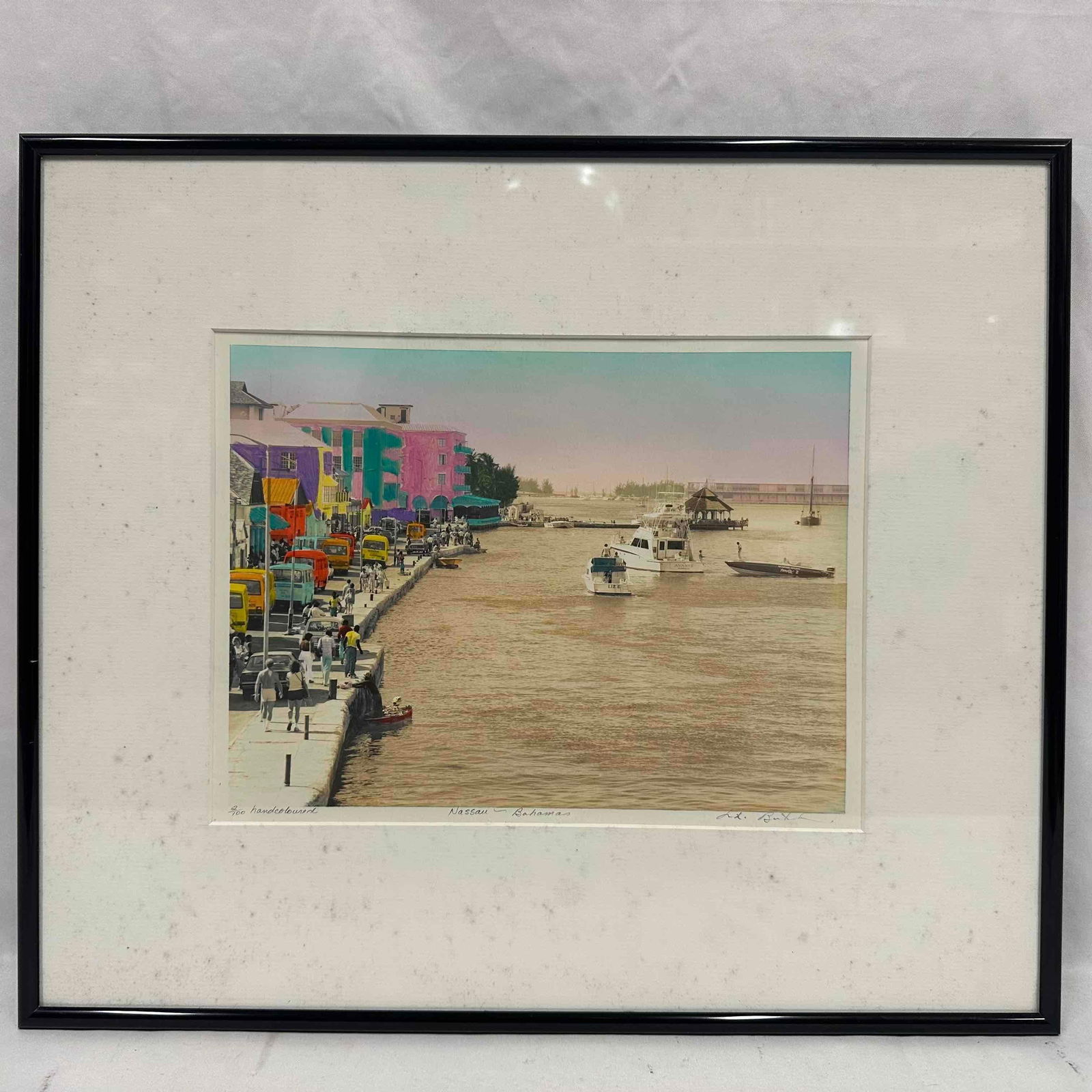 Nassau Bahamas Hand Colored Photograph Niki Butcher 2 out of 100: Limited edition hand-colored black and white photograph depicting a vibrant street and harbor scene in Nassau, Bahamas. Numbered 2/100, signed by the artist, Niki Butcher. Published in 1987. Presented