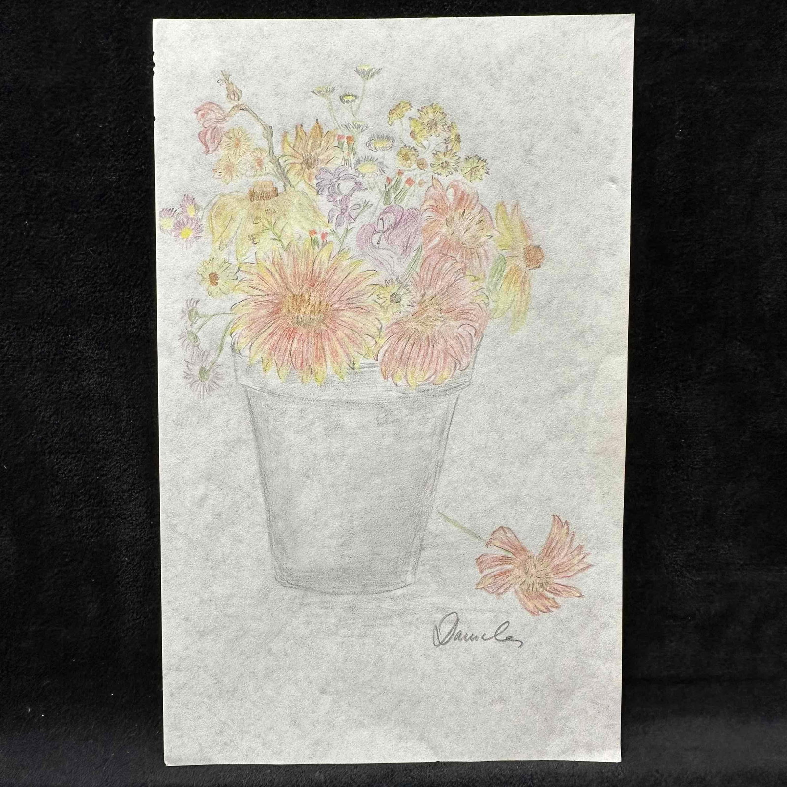 Colored Pencil Floral Still Life Drawing Signed Daniela: Vintage hand-drawn floral still life rendered in soft colored pencil on paper. The artwork depicts a rustic bouquet in a simple pot, accented by a single blossom resting at its base. Signed Daniela at