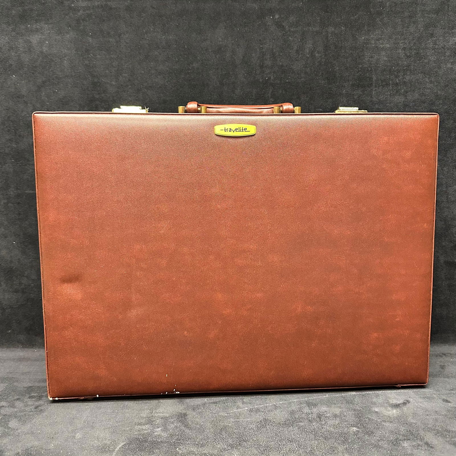 Brown Travelite Leather Briefcase with Combination Locks: Vintage Travelite brown leather briefcase featuring a structured design with top handle and dual brass-tone combination locks. Exterior finished in brown leather with Travelite nameplate to the