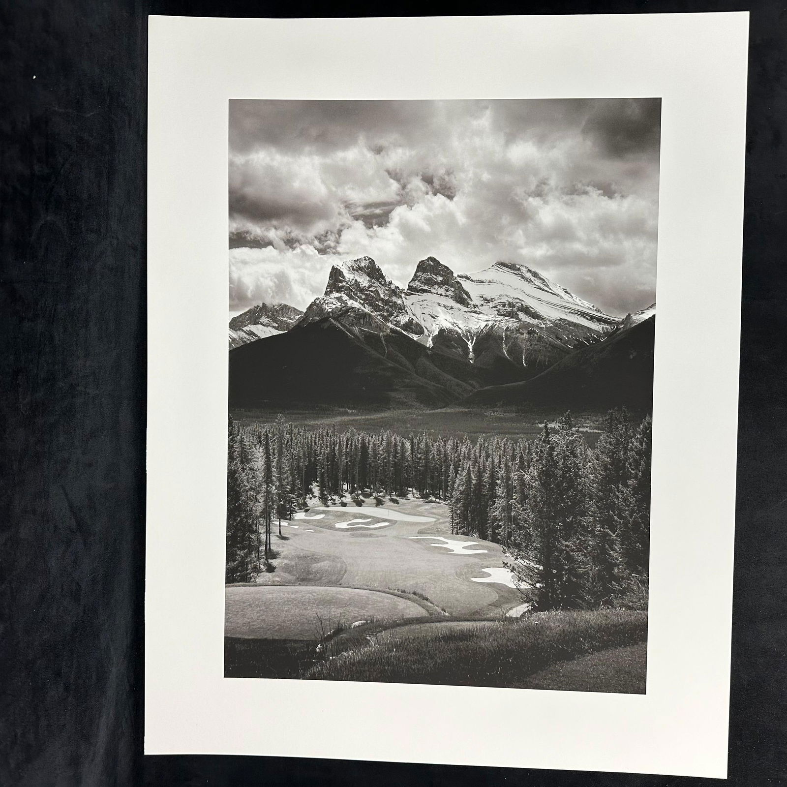Three Sisters Mountain Canmore Alberta Canadian Rockies Black and White Inkjet Photo Print: Black-and-white inkjet photo print featuring the iconic Three Sisters mountain peaks in Canmore, Alberta, part of the Canadian Rockies. The composition beautifully captures a golf course in the