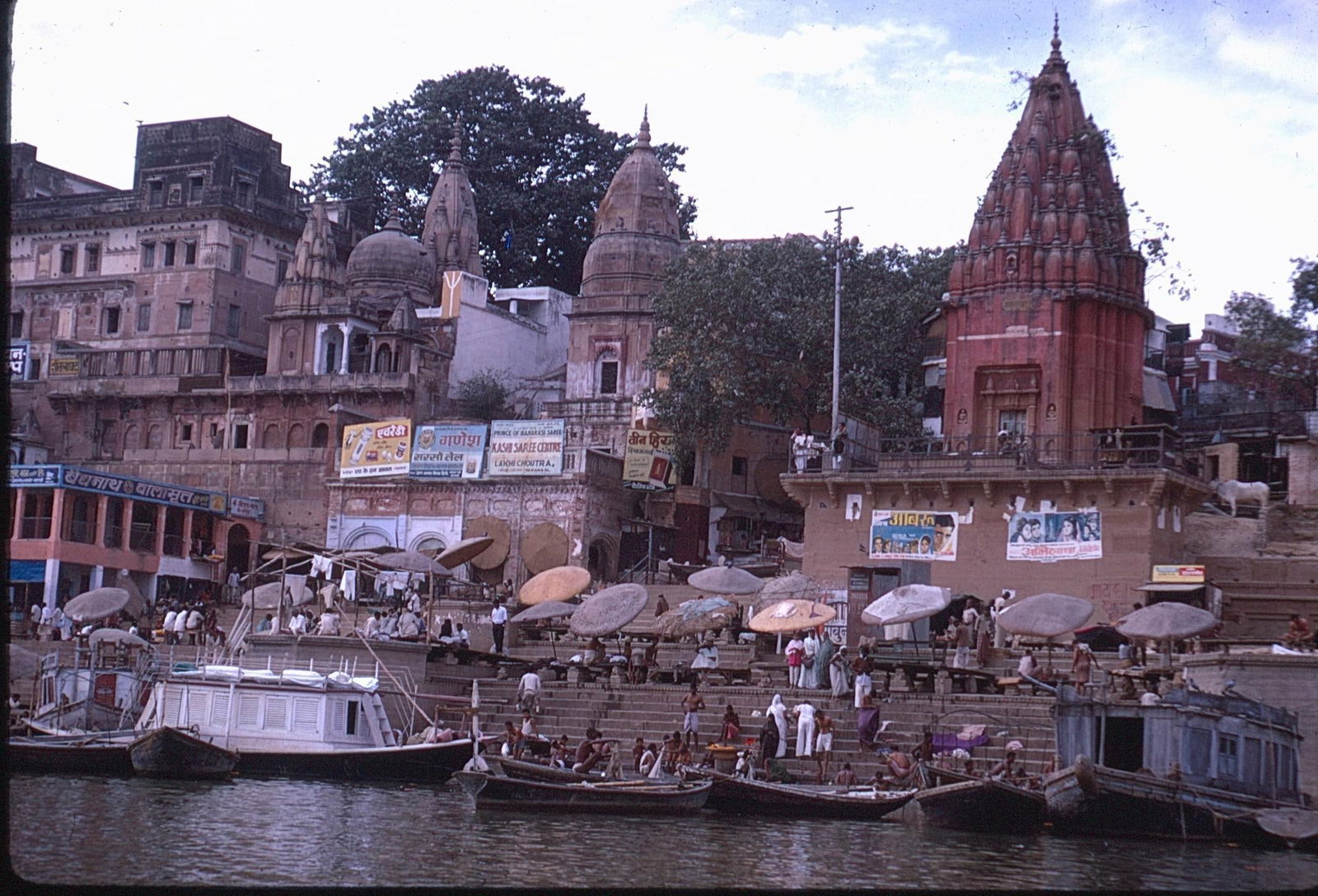 Varanasi Ghats Boats and Temples India Kodachrome Slide and Digital Prints: Vintage 35mm Kodachrome transparency slide with two digital prints depicting a bustling scene along the riverfront ghats of Varanasi, India. The image shows colorful temple architecture, including a