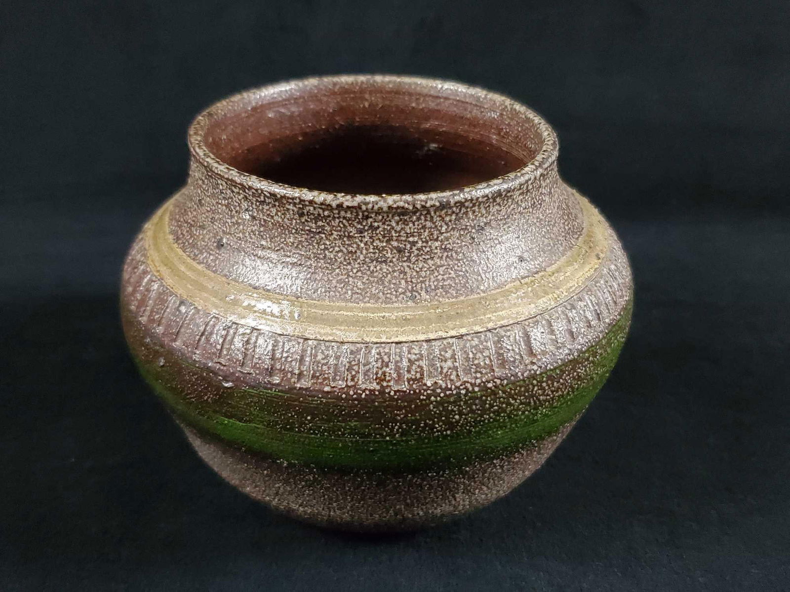 Hand made heavy earthenware pot: Hand made heavy earthenware pot. Glazed with gold and green color stripes, along with small textured parallel lines between colored stripes.Signed on the bottom by an 'T.I". In good, used condition wi