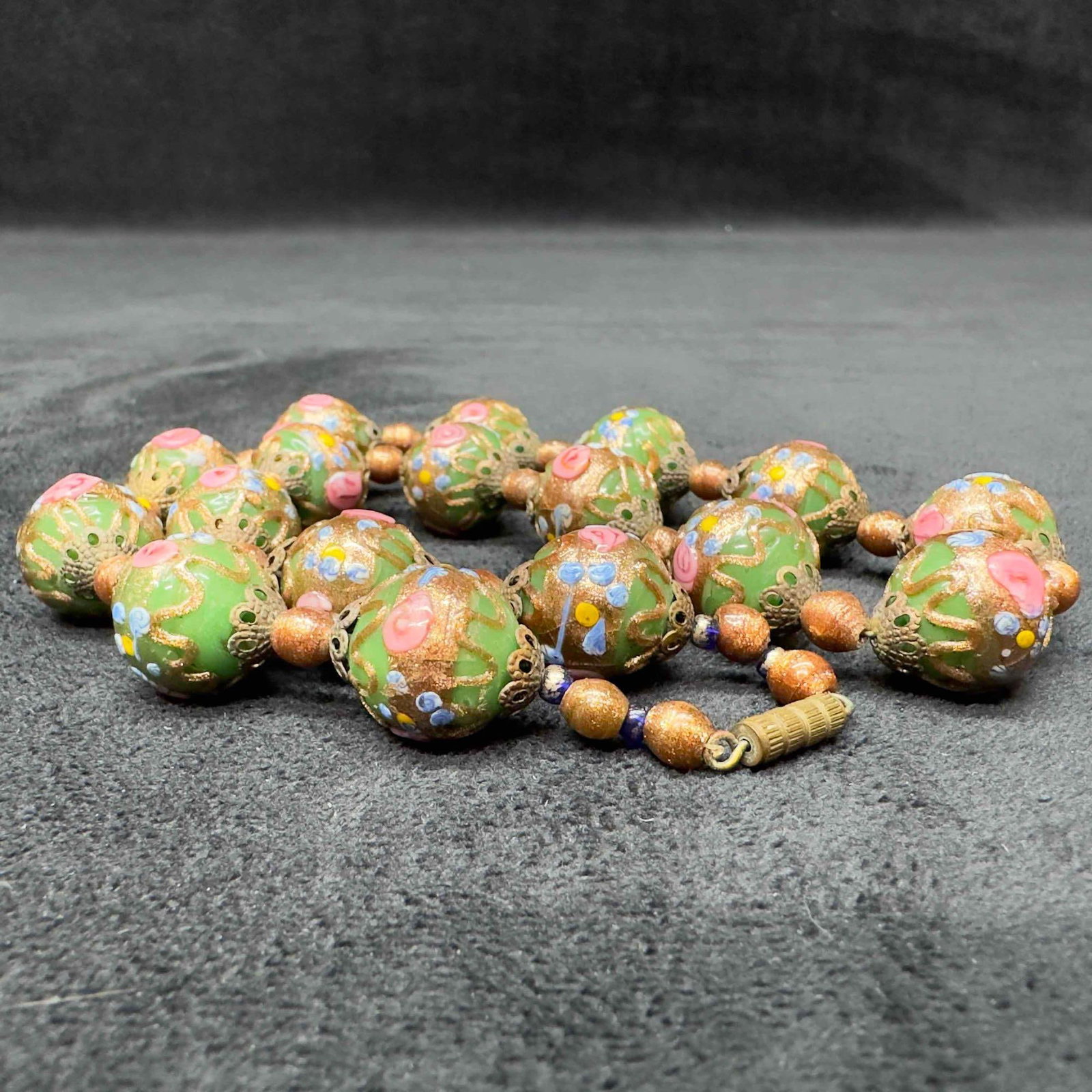 Venetian Murano Lamp Work Glass Green Round Bead Fiorato Floral Beaded Copper Accents Necklace A92: Venetian Murano Lamp Work Glass Green Round Bead Fiorato Floral Beaded Copper Accents Necklace A92. Necklace with green glass beads with beautiful designs on each. The necklace features copper and flo
