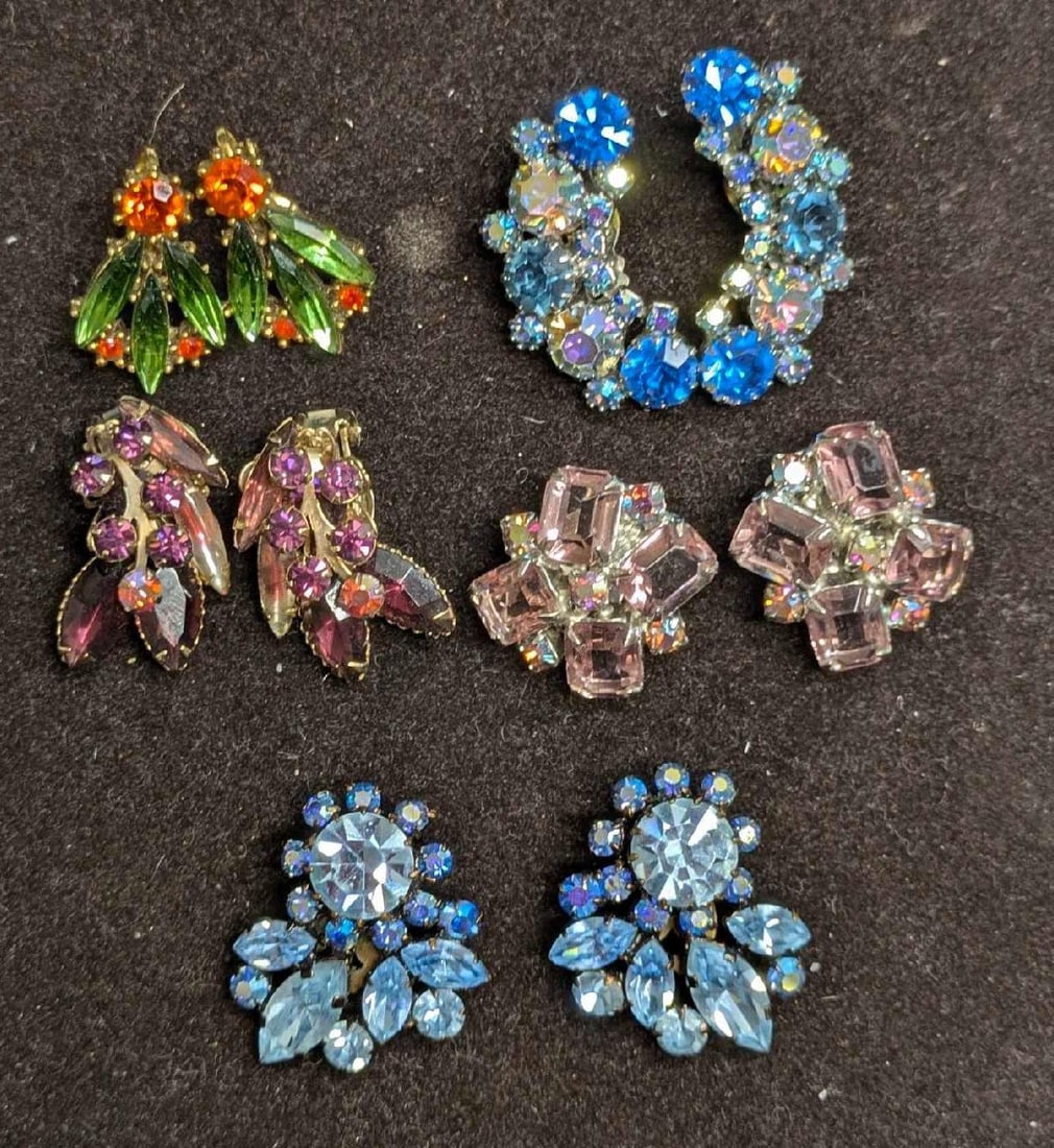 Vintage Unmarked Rhinestones Clip On Earrings Lot Of 5: Vintage Unmarked Rhinestones Clip On Earrings Lot Of 5. This lot includes: (1) Set Of Unmarked Gold Tone Blue AB Crystal Clip On Earrings. Each is approx 1 3/8" x 1/2" x 1/2". The backing