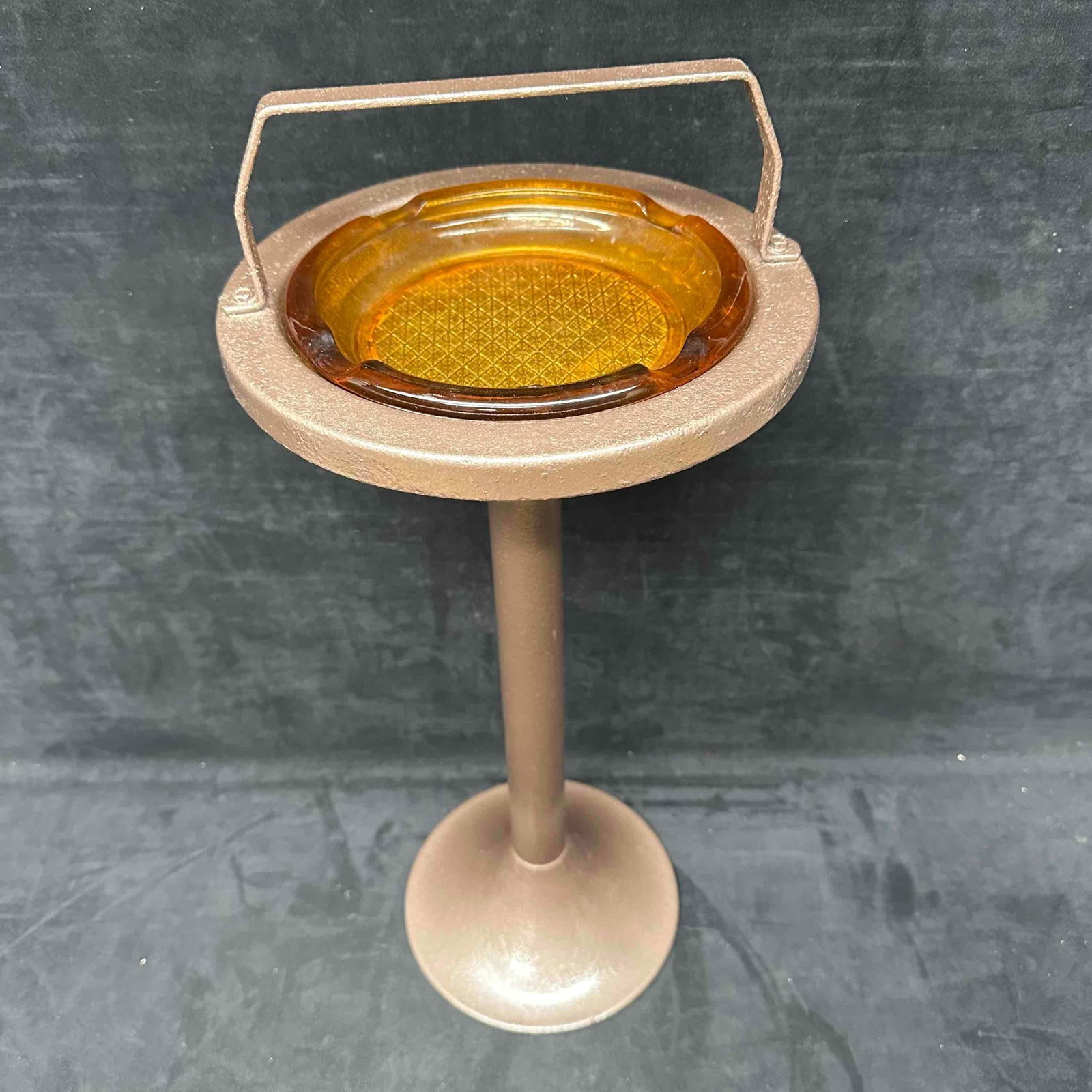 Mid-Century Modern Brown Metal Smoke Stand with Amber Glass Ashtray: Vintage mid-century modern smoke stand featuring a tall brown metal pedestal base and removable amber glass ashtray insert. The piece retains its retro atomic-era style with a simple, functional