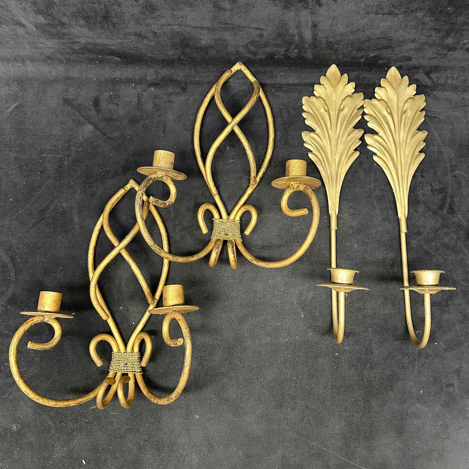 Pair of Metal Gold Colored Wall Sconces Wrought Iron Style and Leaf Design Candle Holders: Lot of two pairs of vintage wall-mounted candle sconces. Includes a pair of large gold-finished wrought iron style double-arm sconces marked Made in India and a pair of single-arm sconces with decorat
