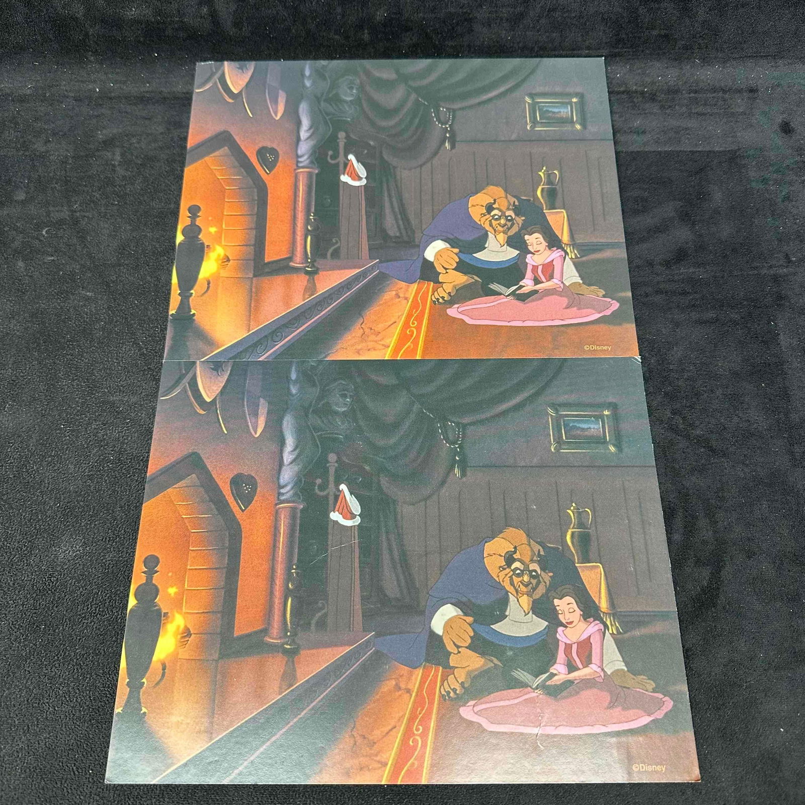 Lot of Two Disney Beauty and The Beast Offset Lithographs Set: Pair of official Disney offset lithographs featuring Belle and Beast reading together in front of the fireplace. Both pieces are printed on heavy card stock with vivid colors and carry the © Disney m