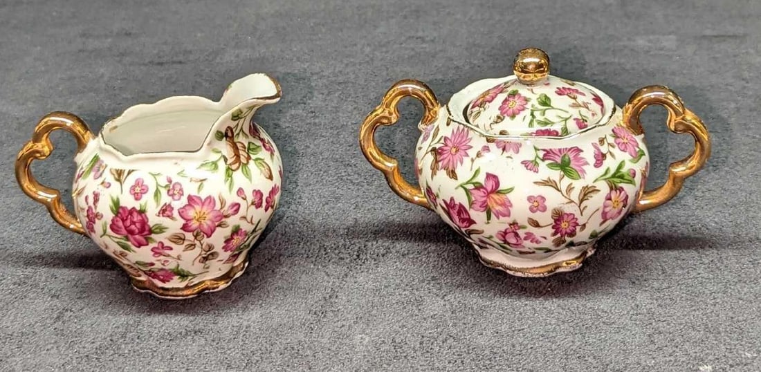Vintage Porcelain Floral Sugar Bowl & Creamer: Vintage Porcelain Floral Sugar Bowl & Creamer. This lot includes: (1) Creamer. This is approx 3 3/4" x 3" x 2 5/8".(1) Sugar Bowl With Lid. This is approx 4 3/4" x 3 1/4" x