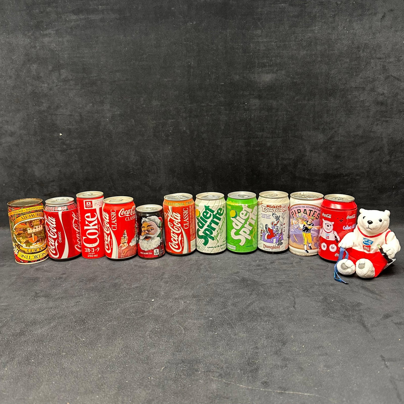 Coca Cola and Soda Beer Advertising Can Collection Sprite Disney: Mixed lot of vintage Coca-Cola, beer, and soda advertising cans, including Coca-Cola Classic, Coca-Cola Zero, international Coca-Cola cans, Sprite and Sprite Caffeine Free examples, and themed cans fe