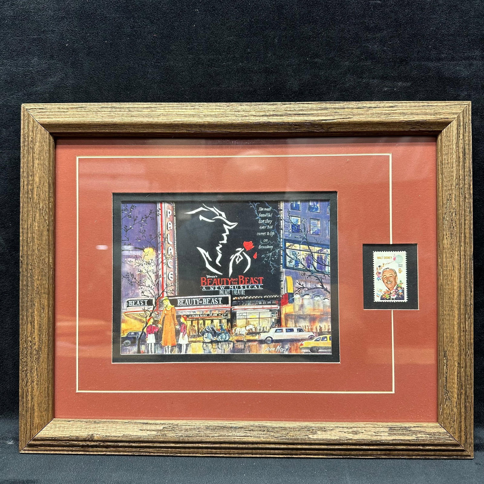 Beauty and the Beast Broadway Framed Anna Marti Artwork with Walt Disney 6 Cent Stamp: Framed Beauty and the Beast Broadway artwork featuring the Palace Theatre marquee and a stylized silhouette design. The artwork is signed Anna Marti on the lower right and includes a mounted vintage U