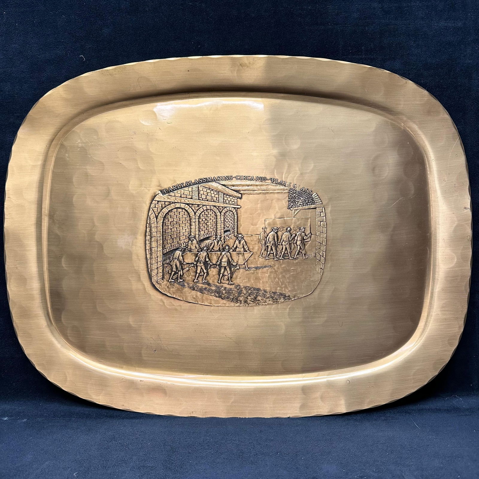 Wendell August Forge Limited Edition Bronze Tray: Handmade bronze tray by Wendell August Forge, issued as a limited edition in 1977 for PPG Auto Glass Industries. Features a hammered finish and a detailed embossed vignette titled Early Glassmaking