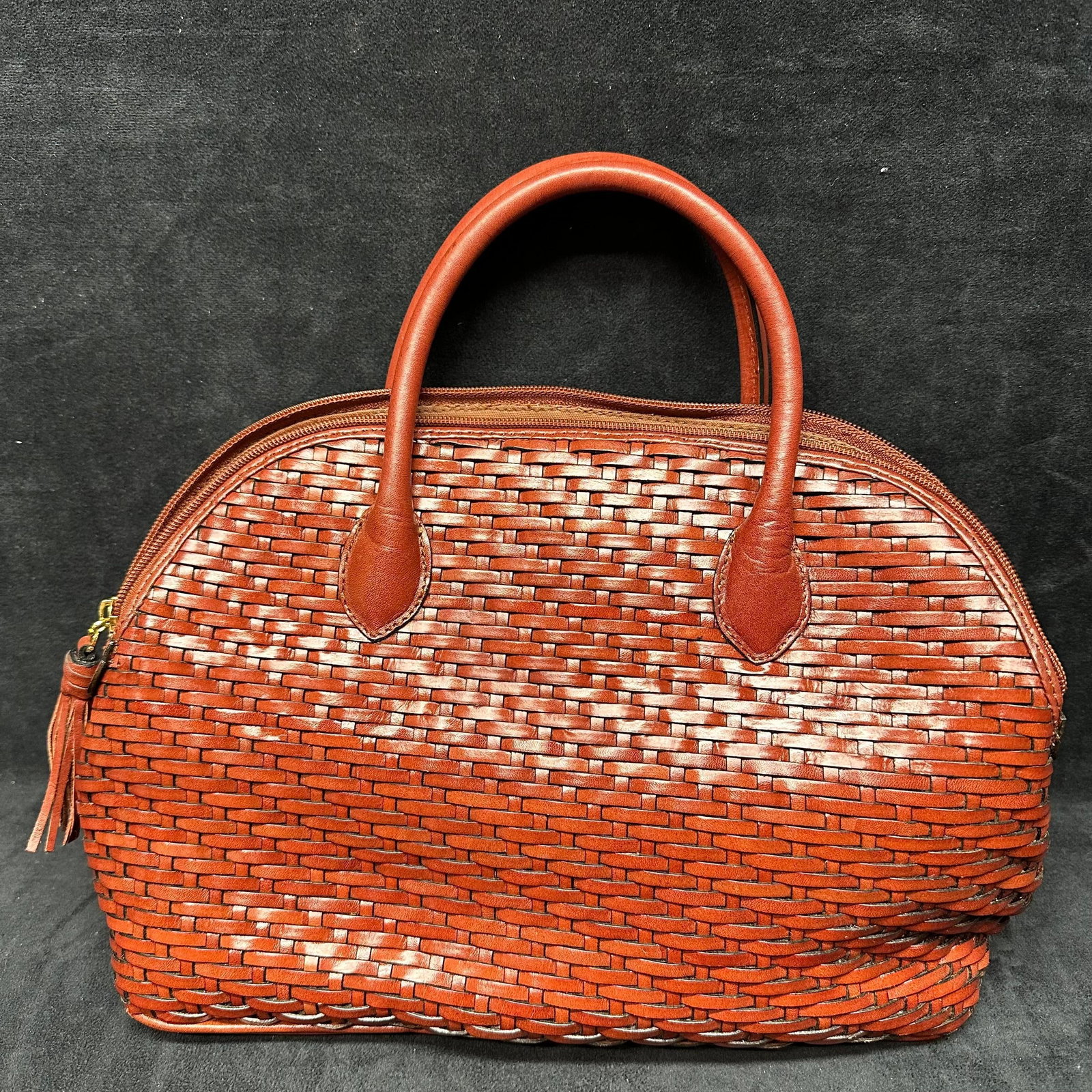 Talbots Woven Leather Satchel Handbag with Double Handles: Talbots brand handbag featuring a woven leather exterior in a warm brown tone. Structured satchel form with double-rolled leather handles and full zip top closure. Lined interior with zip pocket. Fini