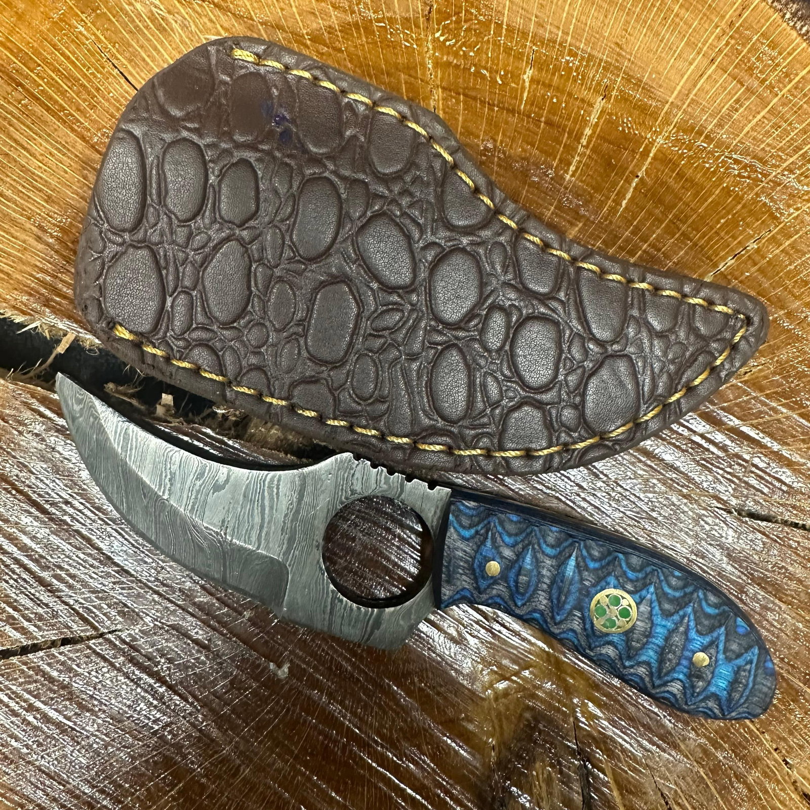 Curved Blade Finger Hole Knife MHS Cutlery Blue Textured Handle R34: Fixed small finger hole blade knife by MHS Cutlery featuring a textured steel blade and decorative spine work. The handle has a contoured, blue epoxy resin/wood-style grip with metal mosaic accents. I