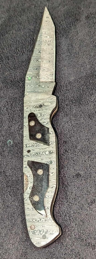 Damascus Steel Fold Up Black Bone Handle Knife Retired C: Damascus Steel Fold Up Black Bone Handle Knife Retired C. Here is a fold-up knife made of imported Damascus steel with a black natural bone handle. These were made in very limited batches by a small c