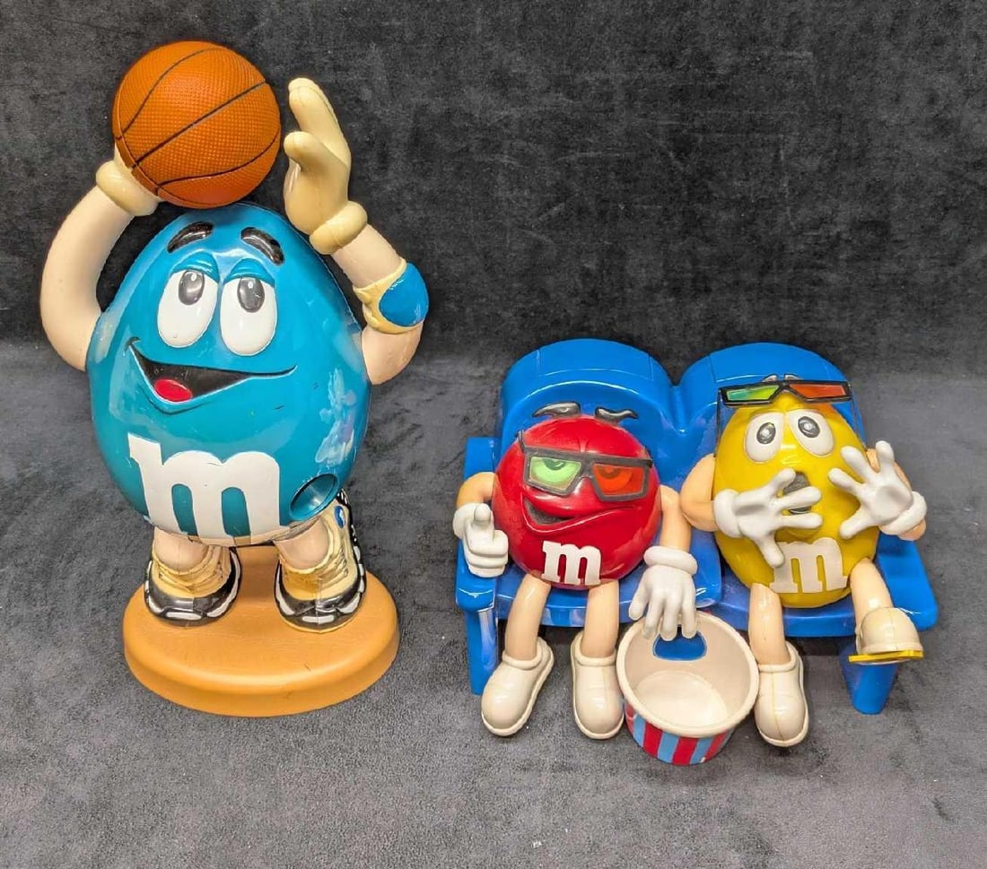 2 M&M Candy Dispenser Movie Seats And Basketball: This lot includes: (1) M&M Basketball Candy Dispenser. This is approx 6" x 4" x 13 1/4".Has color loss, markings and scratches. (1) M&M Movie Theater Seats Candy Dispenser. This