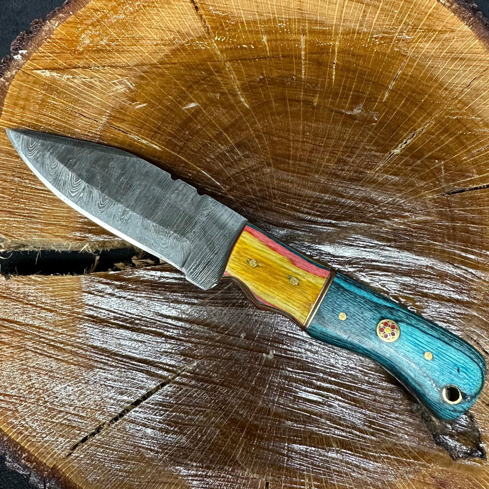 MHS Cutlery Steel Patterned Blade Knife P75 Aqua Color: Fixed blade knife by MHS Cutlery featuring a patterned steel blade with a straight profile. The handle is constructed with multi-tone stabilized epoxy resin/wood material in aqua blue, green, and yell