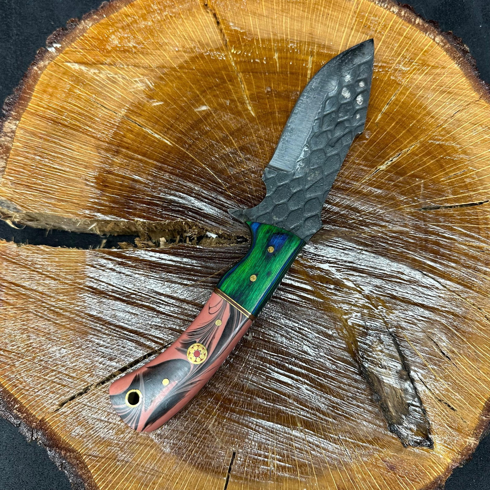 MHS Cutlery Textured Blade Knife Curved Handle P93: Fixed blade knife by MHS Cutlery featuring a textured steel blade and decorative spine work. The handle has a contoured, multi-colored wood/epoxy resin-style grip with metal mosaic pin accents. Includ