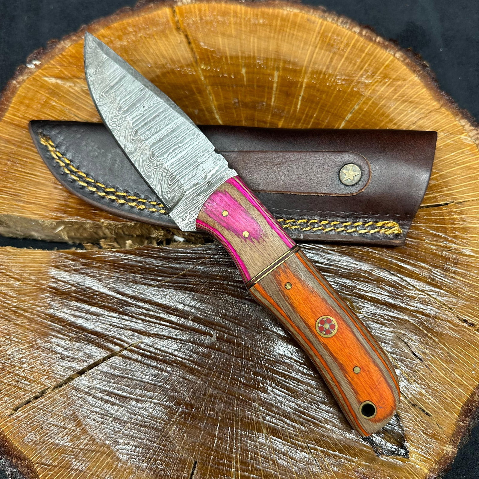 MHS Cutlery Fixed Drop Point Style Blade Knife Q1: Fixed blade knife by MHS Cutlery featuring a textured steel blade and decorative spine work. The handle has a contoured, multi-colored wood/epoxy resin-style grip with metal mosaic pin accents. Includ