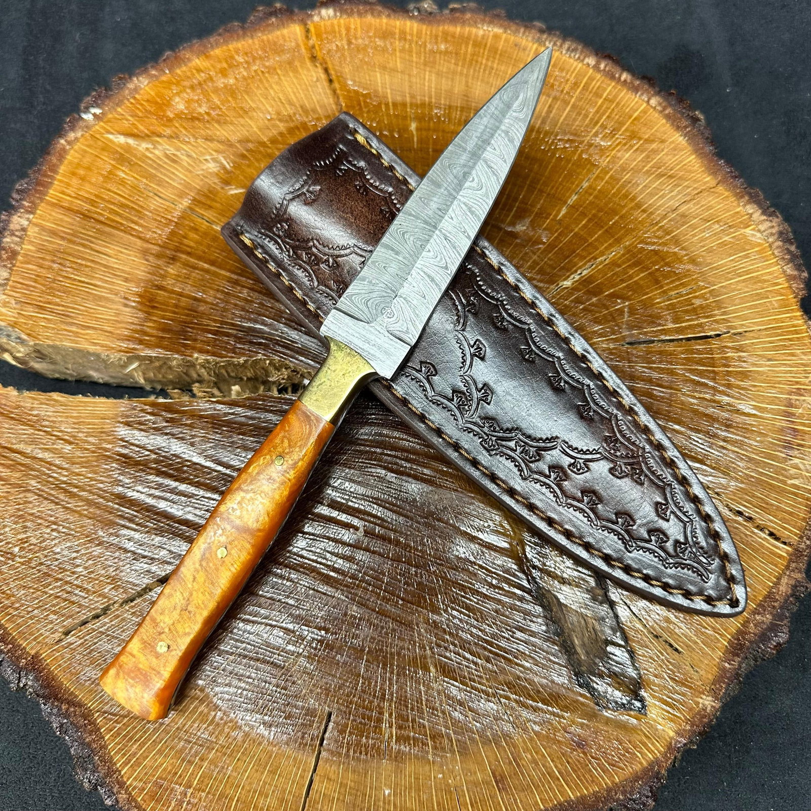Fixed Blade Knife Spear Point Dagger Style MHS Cutlery Q12: Fixed dagger-style blade knife by MHS Cutlery featuring a layered patterned steel blade and decorative spine work. The handle has a contoured, multi-colored wood/epoxy resin-style grip with metal mosa