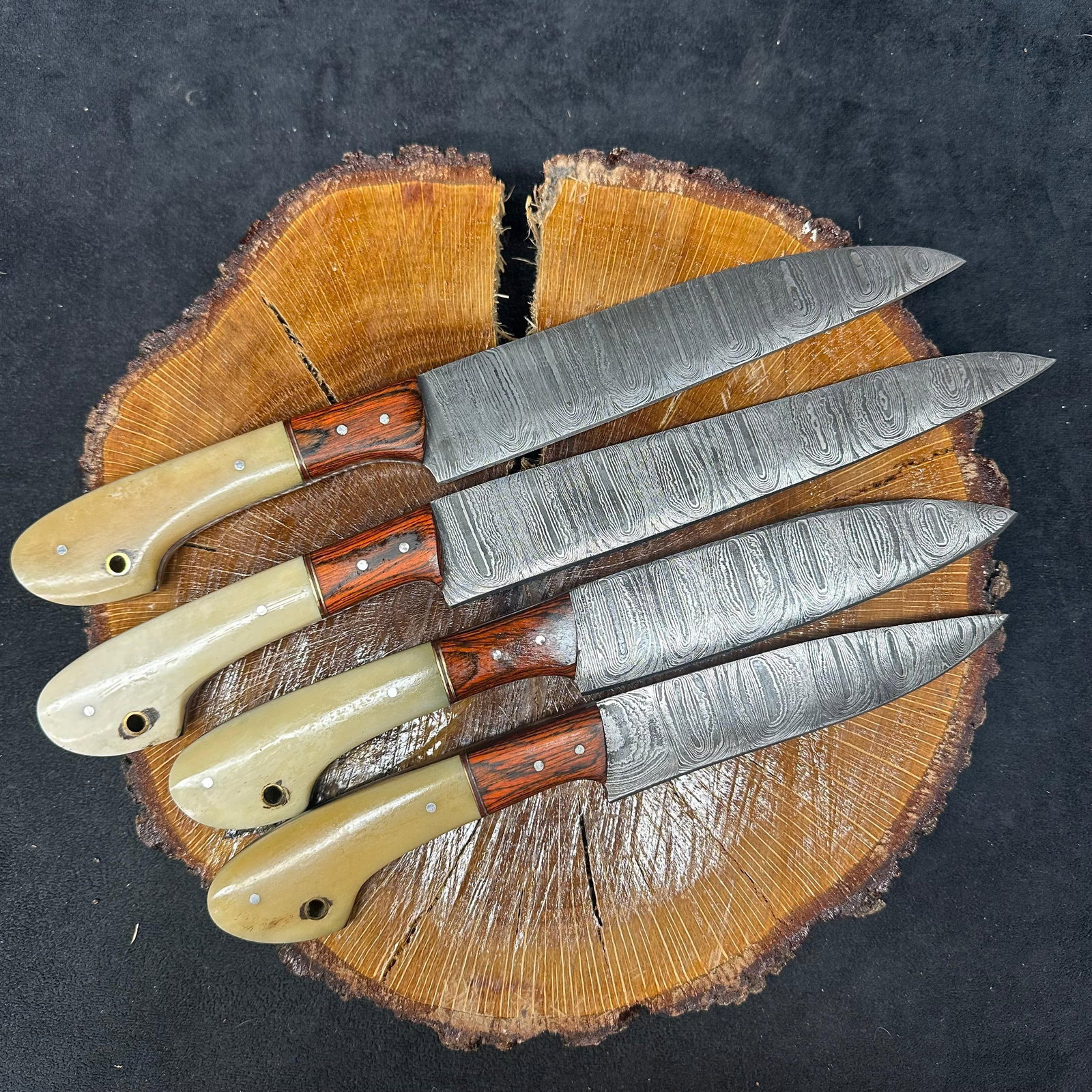 MHS Cutlery Hand-Forged Steel Chef Knife Set 4 Knives Wood Bone Style Tone Handles: Set of four MHS Cutlery hand-forged steel chef knives. Each knife features a patterned style blade with full tang construction, mixed wood and bone-tone handles, and brass pins with lanyard holes. Bla
