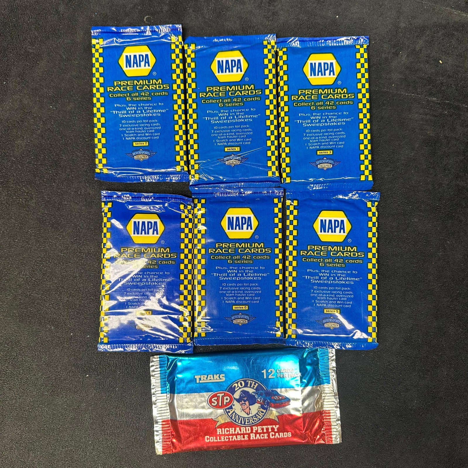 NAPA Premium Race Cards Sealed Packs Lot Plus STP Richard Petty Pack: A lot of sealed motorsports trading card packs, including six NAPA Premium Race Cards packs from various series and one STP 20th Anniversary Richard Petty collectible race card pack. Sealed. Each car