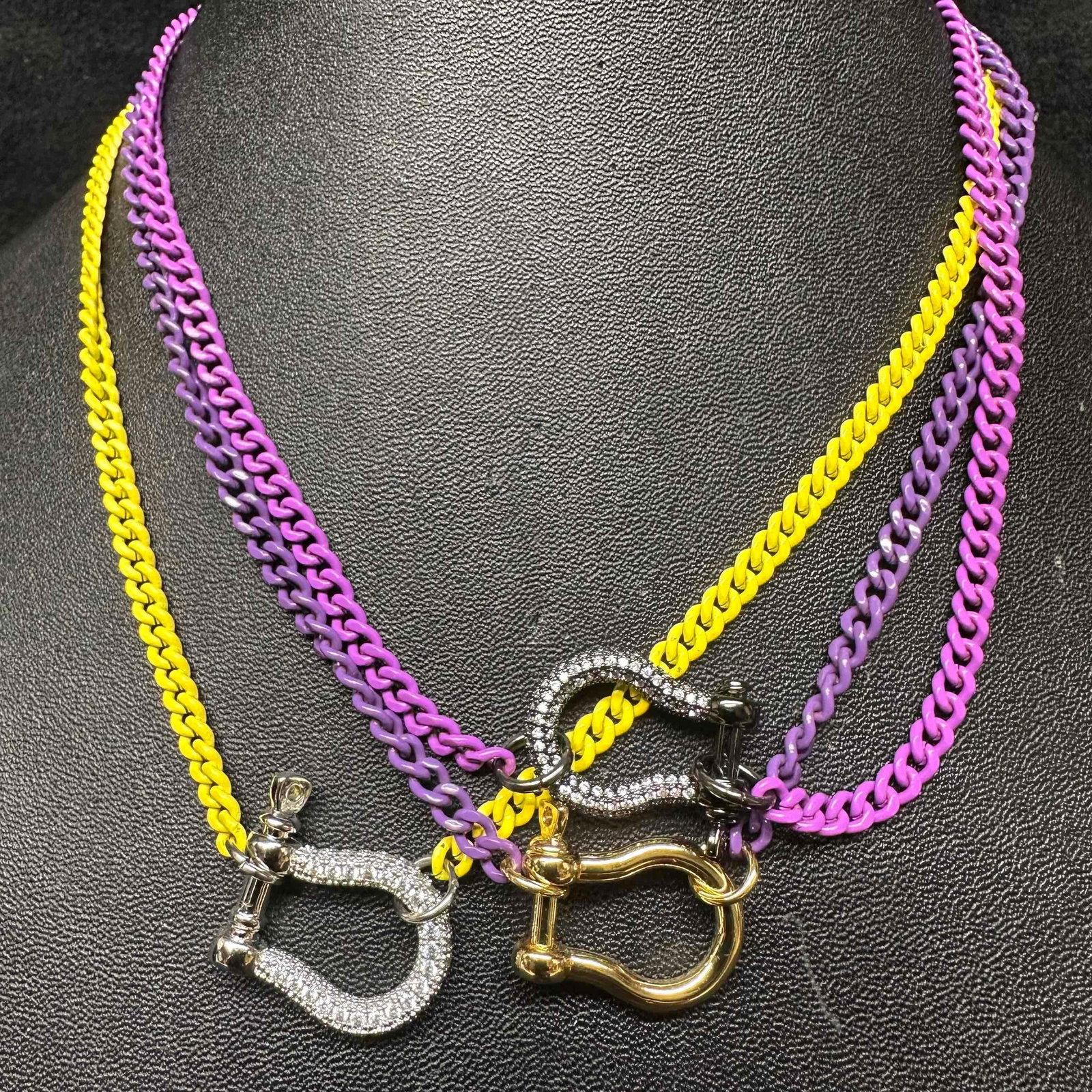 Melania Clara Purple and Yellow Colored Chain Assorted Necklace Set Modern Style: The Melania Clara necklace set features a magnet clasp closures. Each necklace showcase modernist designs with a purple shade or yellow toned chain style. These items are in good pre-owned, previously