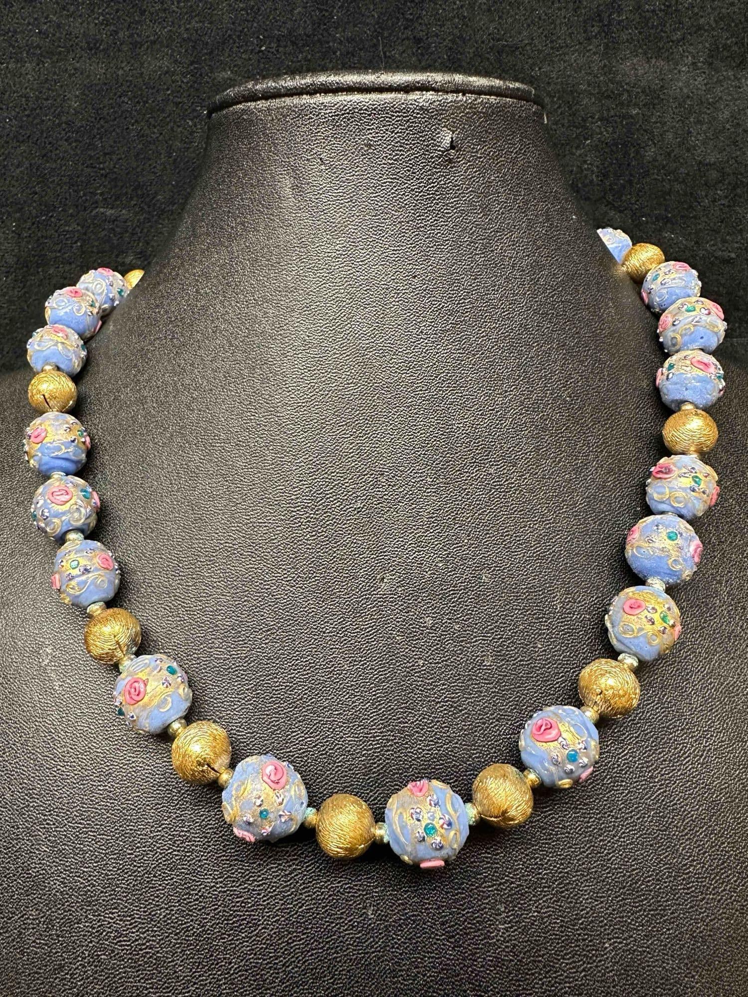 Venetian Murano Lamp Work Glass Art Light Blue Round Gold Accent Beaded Necklace E93: Venetian Murano Lamp Work Glass Art Light Blue Round Gold Accent Beaded Necklace E93. Necklace with light blue colored glass beads with a beautiful design on each. The necklace features pink colored a