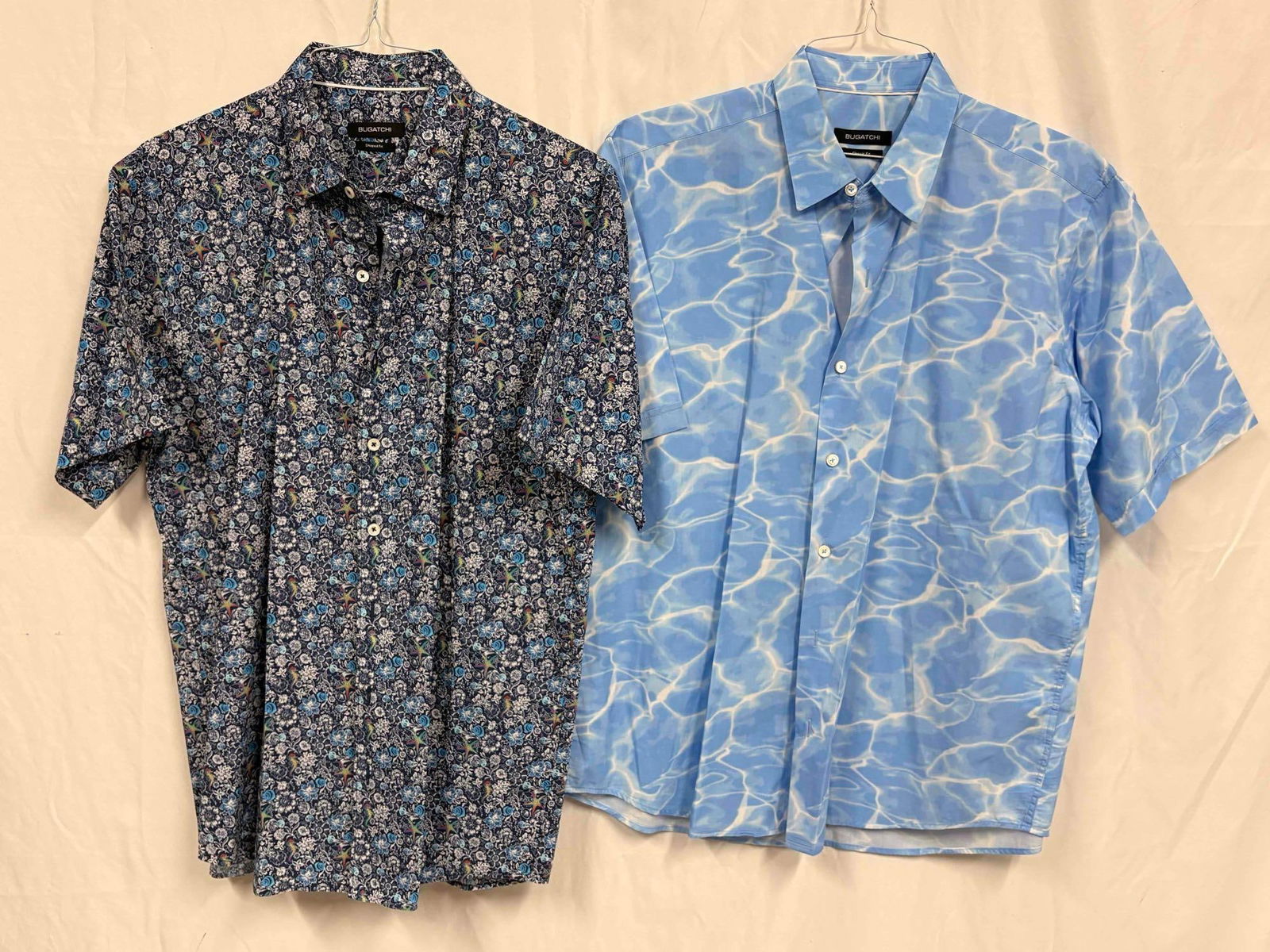 2PC Bugatchi Oceanic Mens Hawaiian Shirt Bundle: This lot contains a set of men's short sleeve dress shirts by Bugatchi, a luxury menswear brand founded in the 80s. Both shirts are a size Large, standing in like-new conditions without tags. Plea