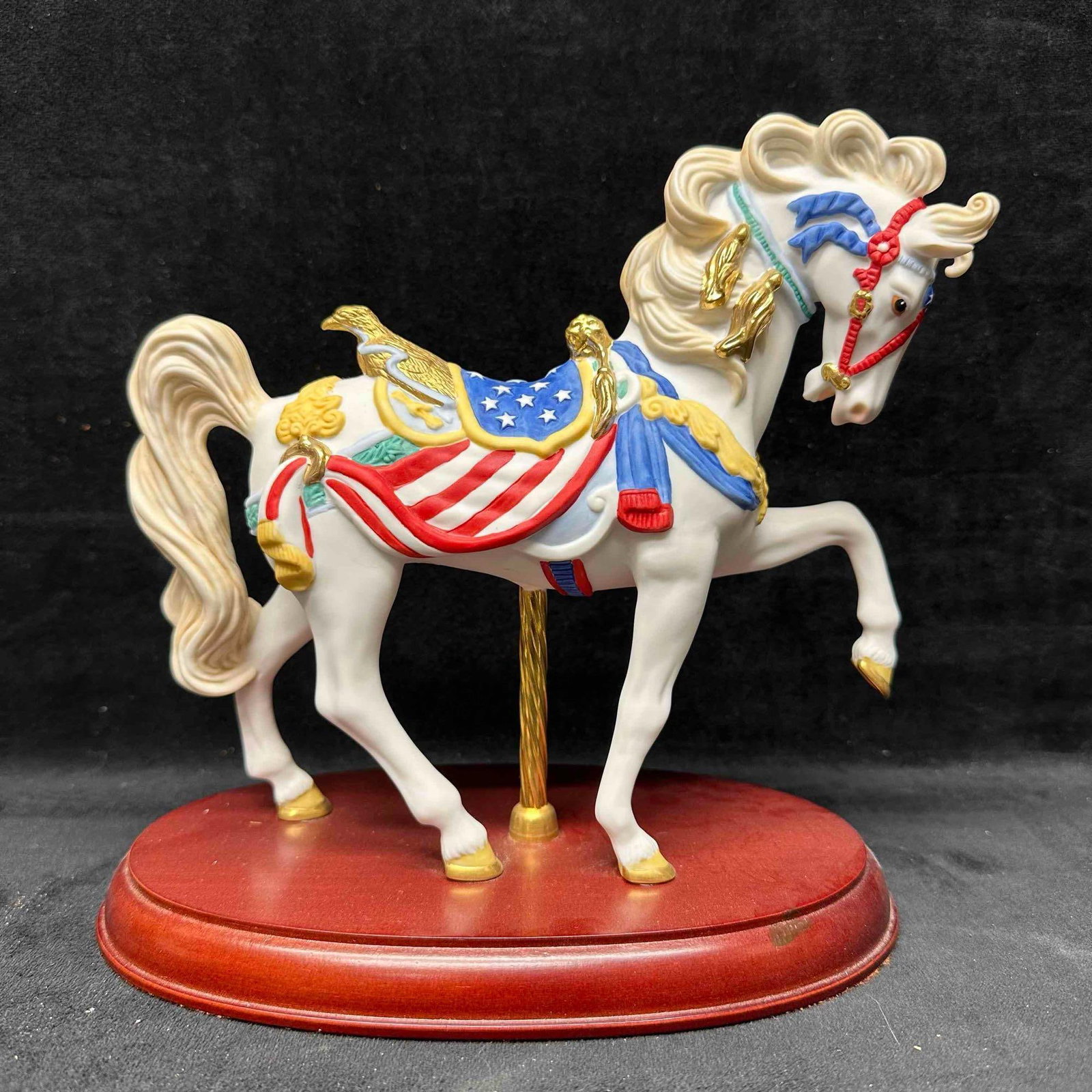 Lenox Pride of America Carousel Horse Hand Crafted Porcelain 24K Gold Accents Sculpture: 1991 series edition. This collectible figurine is crafted from fine porcelain and meticulously hand-painted with accents of 24 karat gold. This item is in good pre owned, previously displayed conditio