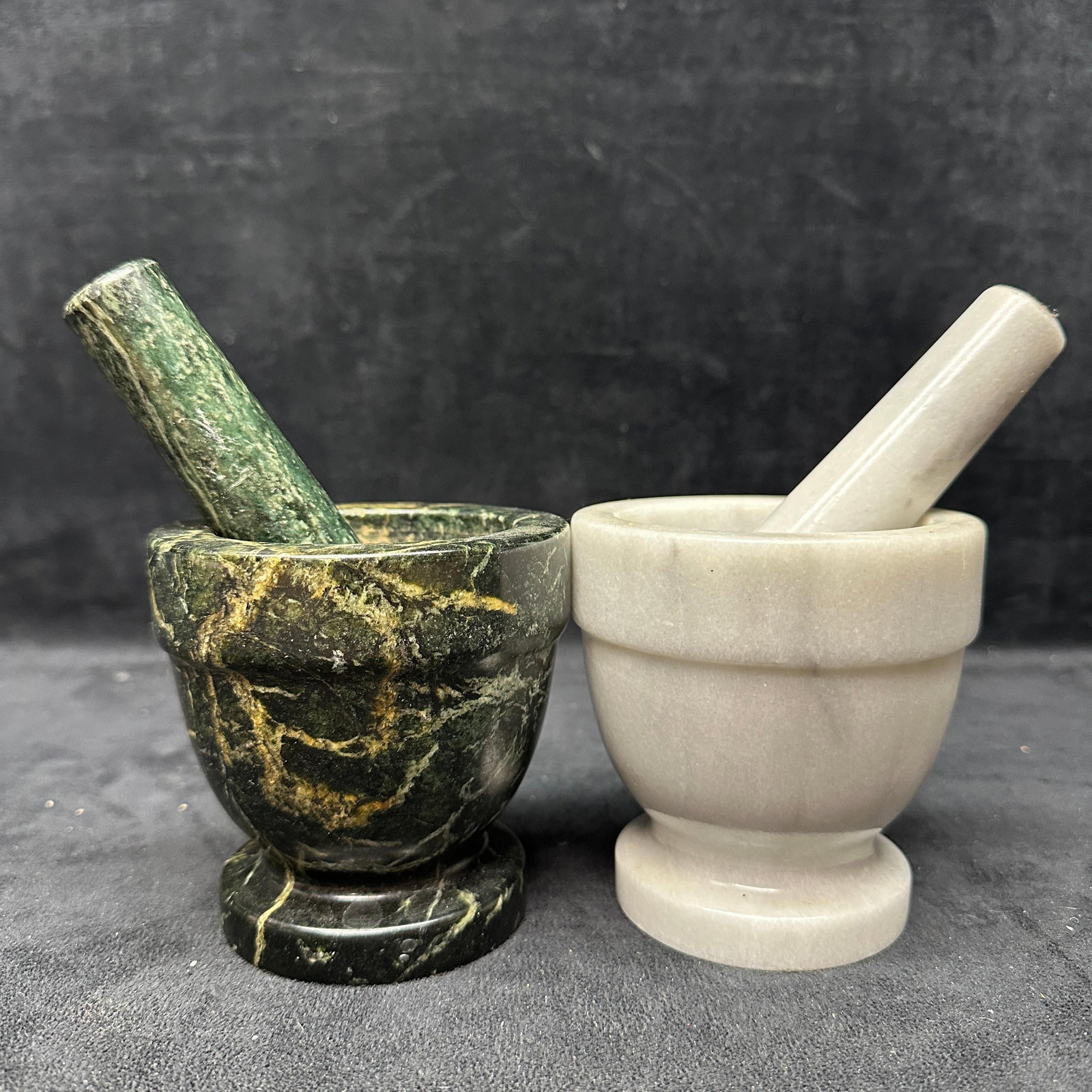 Two Stone Mortar And Pestle Sets Marble And Soapstone: Group of two mortar and pestle sets, including one dark green veined marble example and one light gray soapstone example. Each set includes a matching pestle. Light wear consistent with use, including