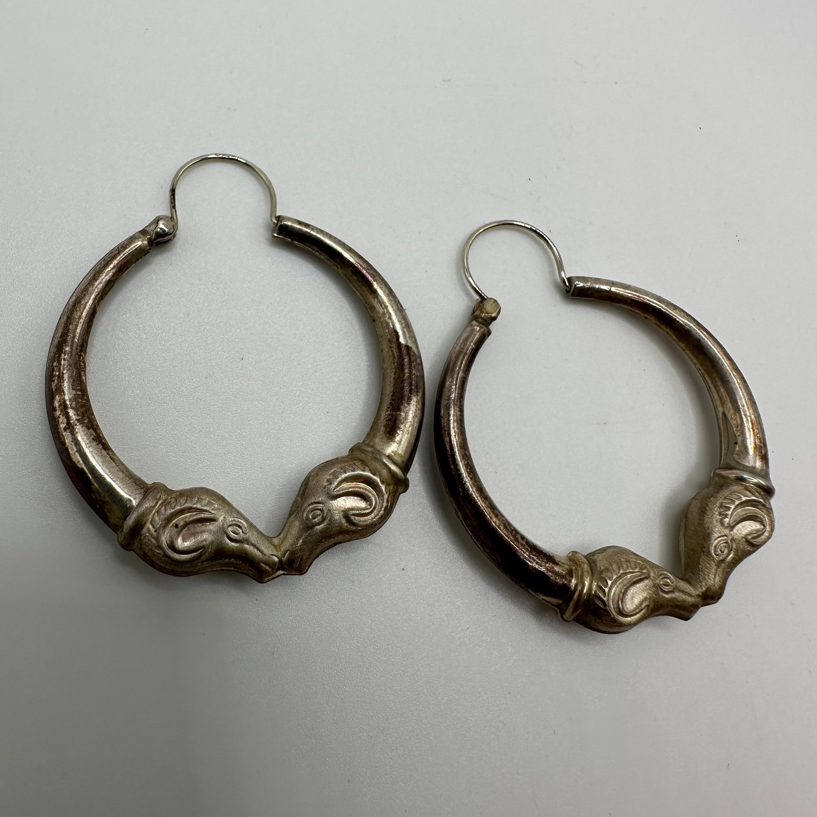 Double Ram Head Silver Hoop Earrings Q73: This item is in good pre-owned, previously used/displayed condition with noticeable light wear and surface scratches. Please reference all photos for full details. This piece of jewelry has been teste