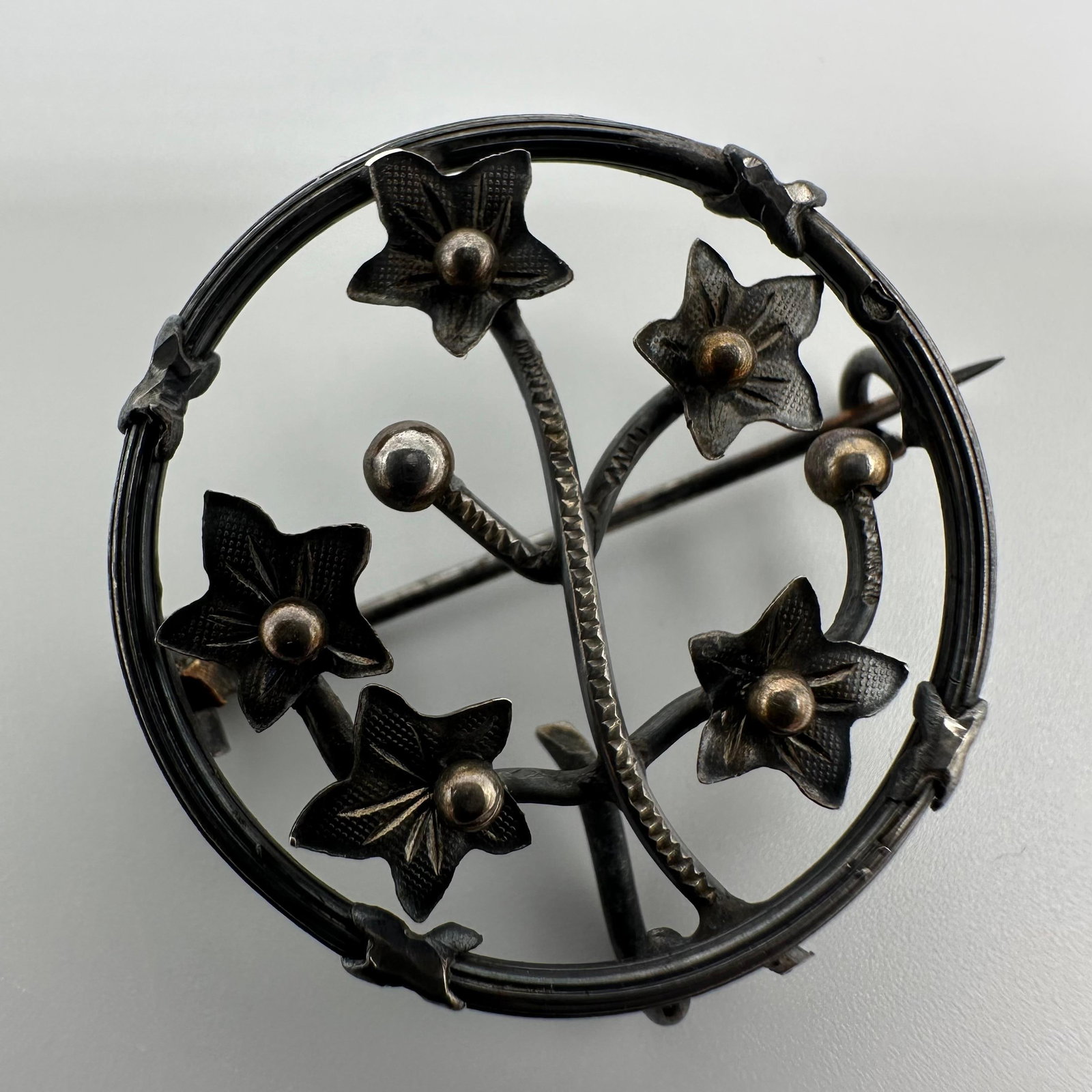 Circular Floral and Vine Motif Silver Brooch Q55: This item is in good pre-owned, previously used/displayed condition with noticeable light wear and surface scratches. Please reference all photos for full details. This piece of jewelry has been teste