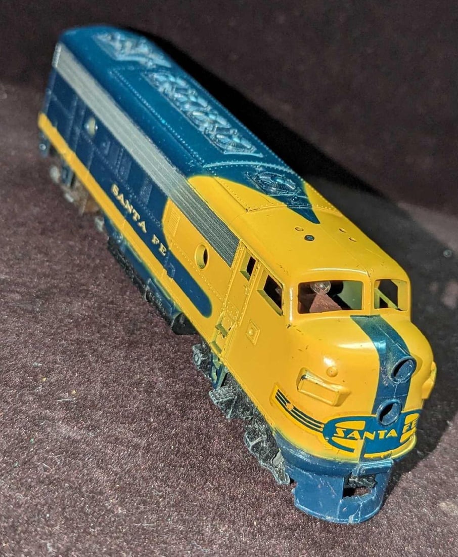 Vintage HO Scale Santa Fe Locomotive: Vintage HO Scale Santa Fe Locomotive. Its maker and date of creation is unknown. Untested. Is approx 7 1/4" x 1 1/2" x 2" and it weighs 0.64lb. The top horn and couplers are missing. Please see the