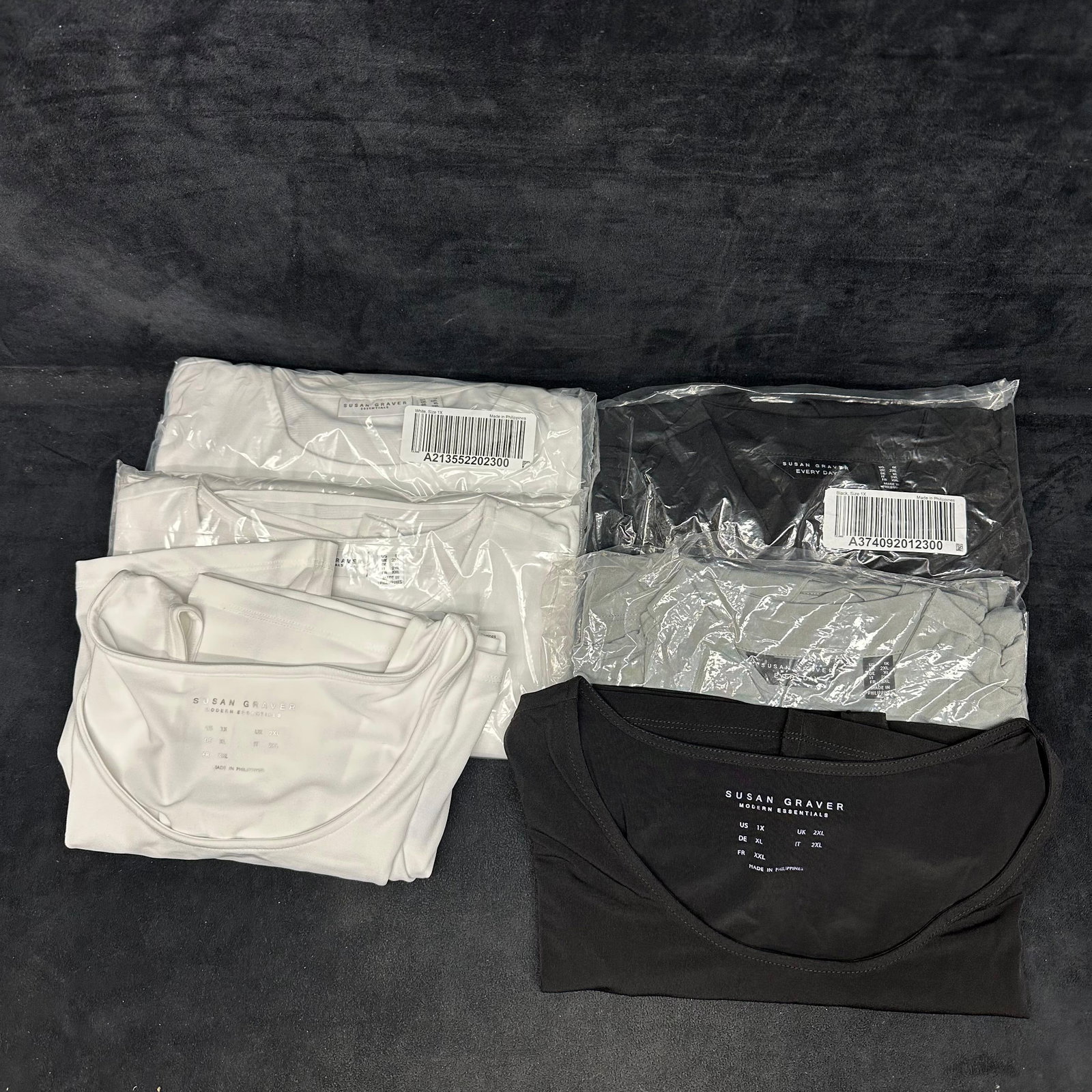 Susan Graver Essentials 1X Clothing Lot of Six Tops: Group of women's Susan Graver tops all sizes 1X—mixed colors and styles. These items are in like-new, previously stored condition with wear and surface markings on the outer packaging. Please