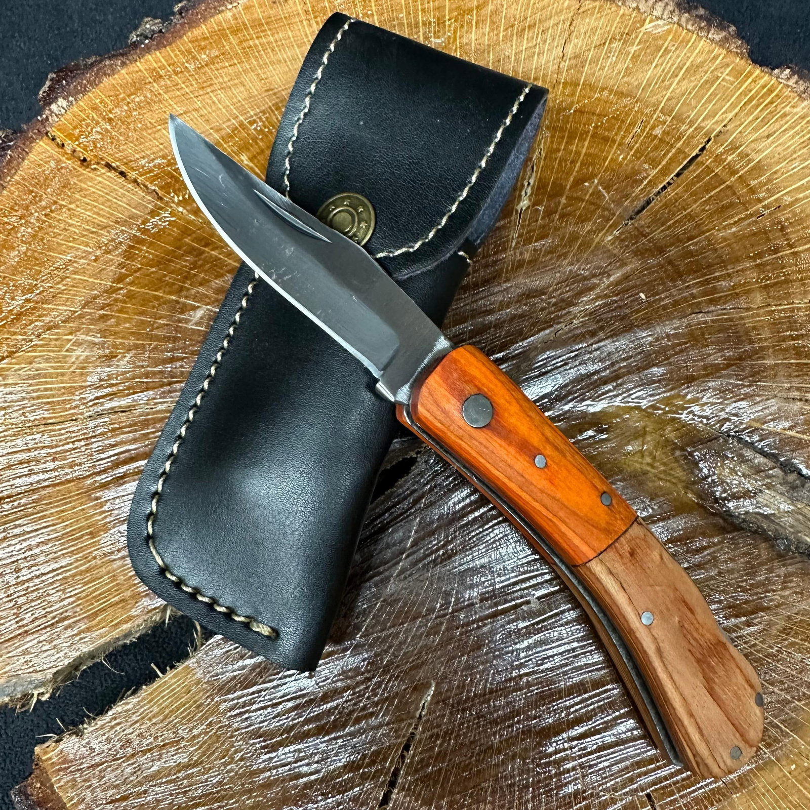 MHS Cutlery Steel Folded Blade Pocket Knife Orange Wood Style Handle Q87: Folding blade pocket knife by MHS Cutlery featuring a steel blade and decorative spine work. The handle has a contoured, orange wood/resin-style grip with metal mosaic pin accents. Includes a fitted b
