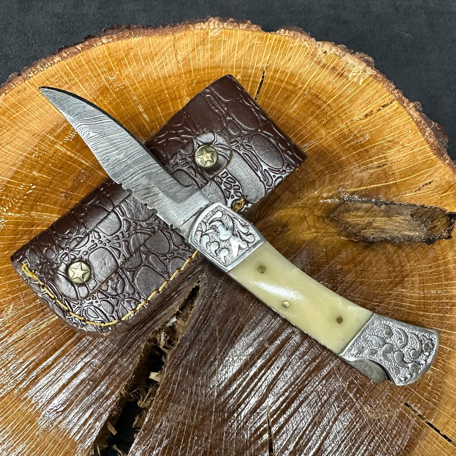 MHS Cutlery Folded Blade Pocket Knife Bone Tone Wood Style Handle Q89: Folding blade pocket knife by MHS Cutlery featuring a layered patterned steel blade and decorative spine work. The decorative handle has a contoured, wood/resin-style grip with metal mosaic pin accent