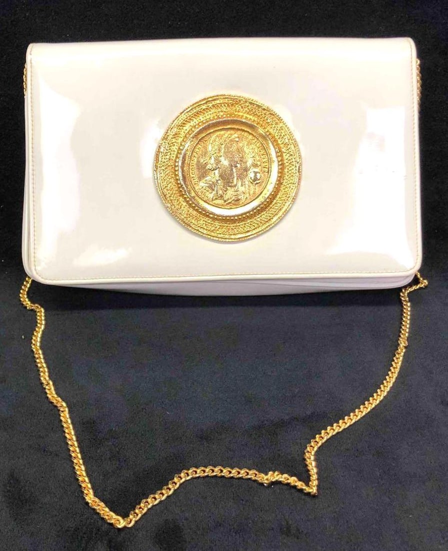 Morris Moskowitz Woman's Faux Leather Shoulder Bag: This lot contains a vintage Morris Moskowitz faux leather purse. This white faux leather bag features one gold chain, a button clasp for closing, and two pockets on the inside one with a zipper a