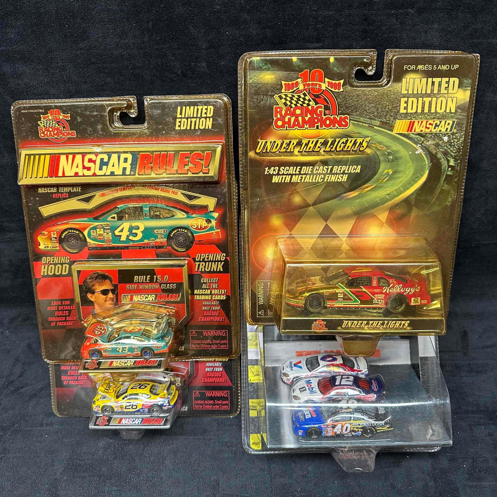 Racing Champions NASCAR Limited Edition Diecast Car Lot of 1:64 and 1:43 Scale Cars: Collection of Racing Champions Limited Edition NASCAR diecast cars. Includes one 1:64 scale Richard Petty #43 STP “NASCAR Rules!” car with opening hood and trunk, one 1:64 scale #26 NASCAR Rul