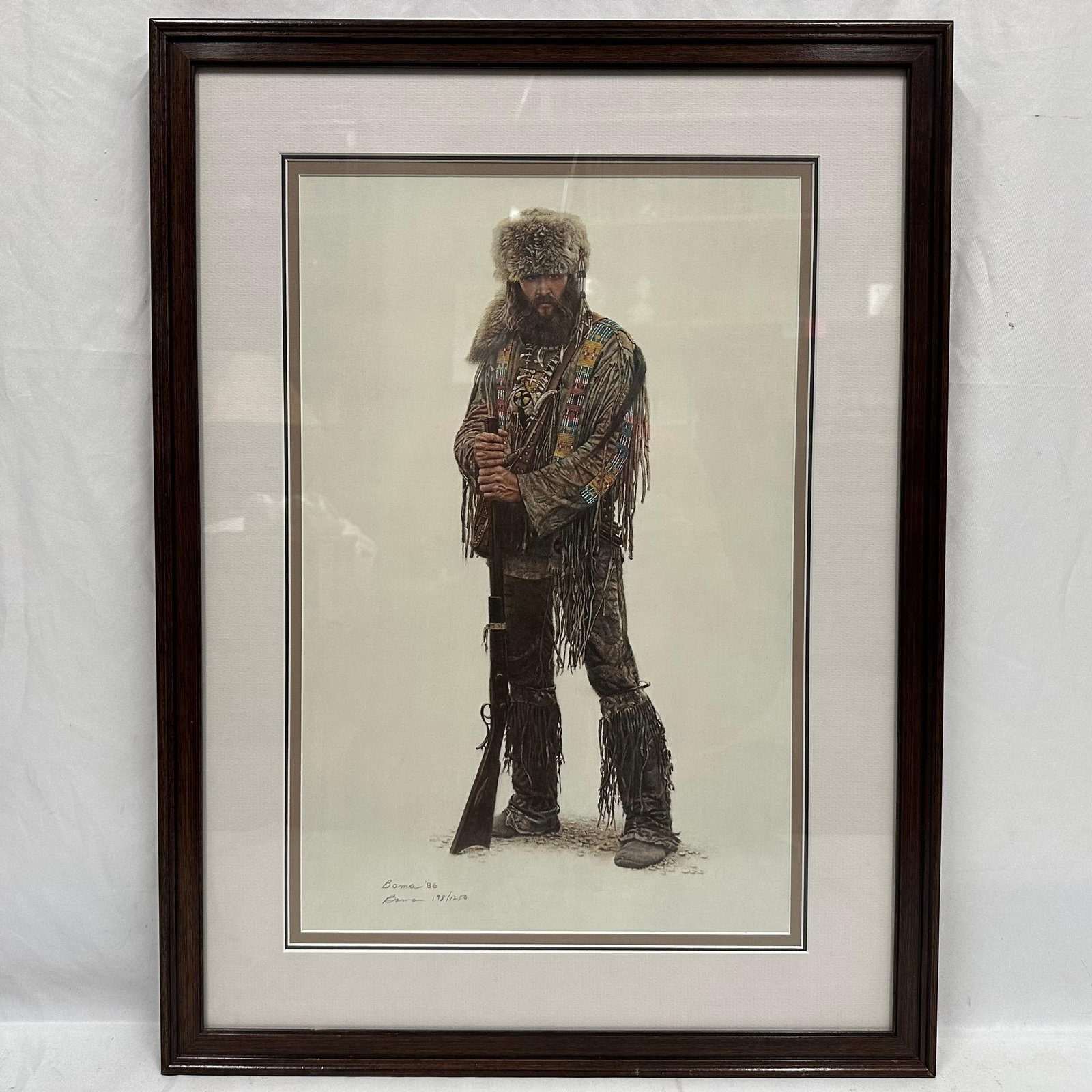 James Bama Signed and Numbered Print Mountain Man with Rifle Wood Frame: Framed and matted James Bama limited edition print, signed, numbered, and dated “Bama ’86” and numbered 198/1250. Portrait of a frontier mountain man holding a rifle, detailed period clothin