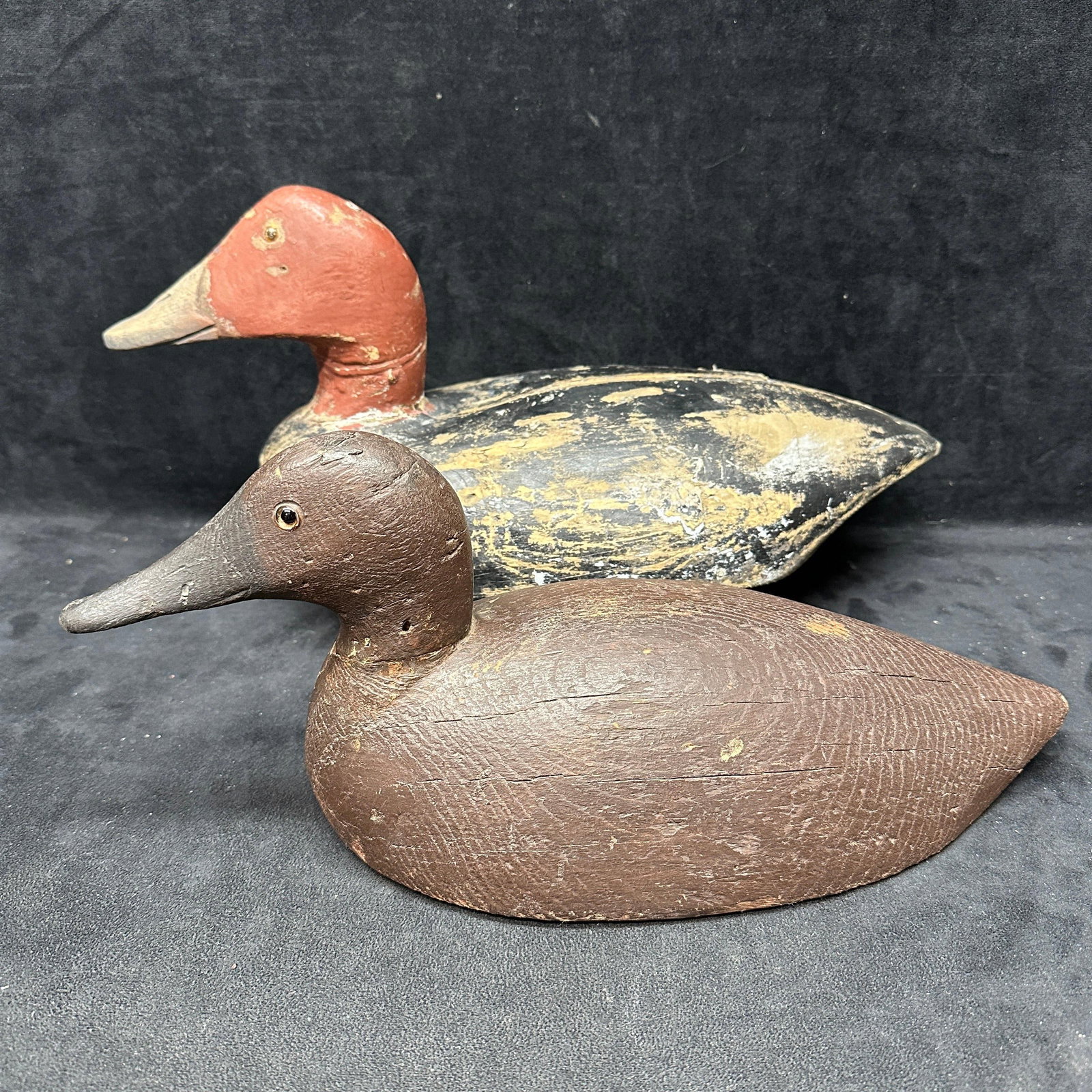 Pair Vintage Hand Carved Wooden Duck Decoys B Gee DL Marked: Pair of vintage hand-carved wooden duck decoys with painted finishes and glass eyes. One decoy marked “B. Gee” to underside with a weighted keel, the other marked “DL.” Showing surface