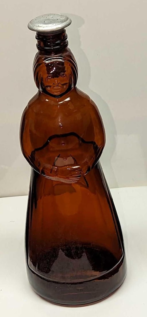 Vintage Mrs Butterworth Amber Glass Sprinkle Bottle: Vintage Mrs Butterworth Amber Glass Sprinkle Bottle. The vintage bottle's cork was replaced with an added sprinkler. This is approx 4" x 4" x 10 1/2" and it weighs 1.04lb. The glass bottle has some sm