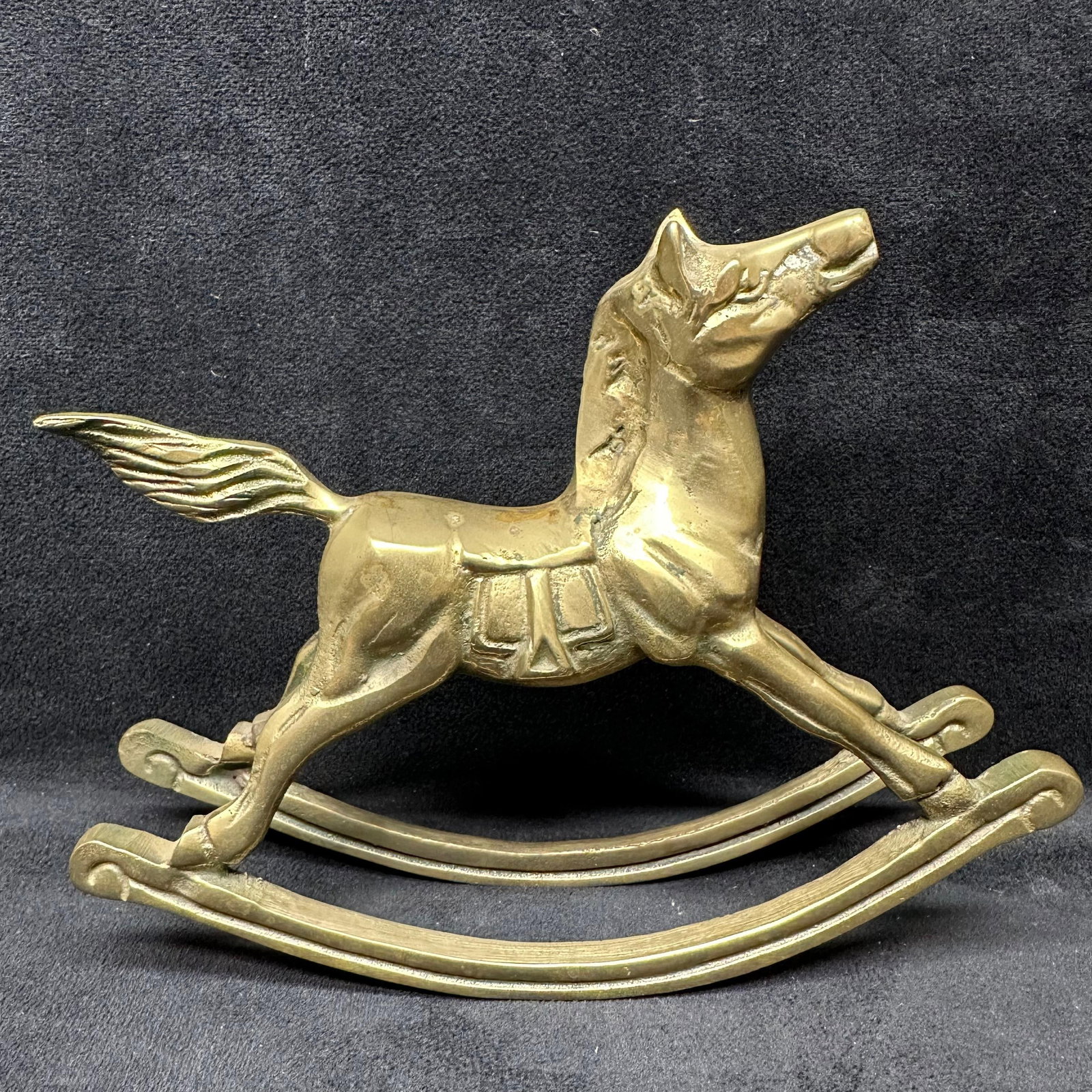 Solid Brass Rocking Horse Figurine: Vintage solid brass rocking horse with elegant form and sculpted detail. Features smooth lines, raised tail, and traditional saddle design. This item is in pre-owned, previously displayed condition