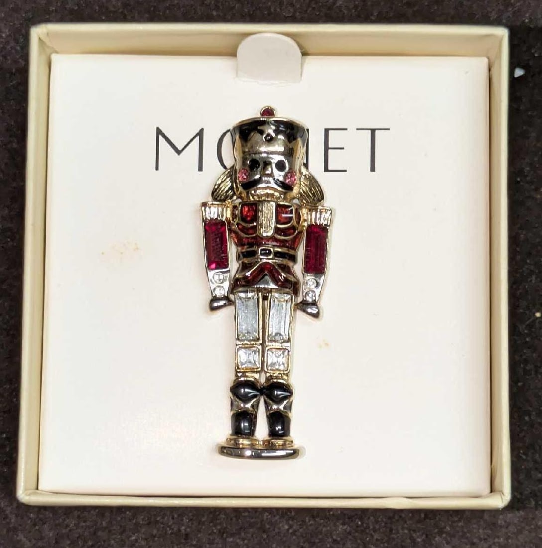 Monet Gold Tone Red Enamel Rhinestone Nutcracker Brooch: Monet Gold Tone Red Enamel Rhinestone Nutcracker Brooch. It comes in the original box that is approx 3 1/8" x 3" x 2" and it weighs 0.09lb. The brooch is approx 7/8" x 3/8" x 2 1/8". The box has some 