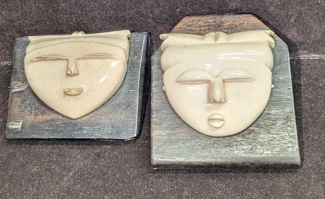 2 Vintage Carved Masks Mounted on Ebony in Japanese Style: 2 Vintage Carved Masks Mounted on Ebony in Japanese Style; these carved masks are in an ivory-like material. They are mounted on blocks of ebony and show a very stylistic appearance. There are no
