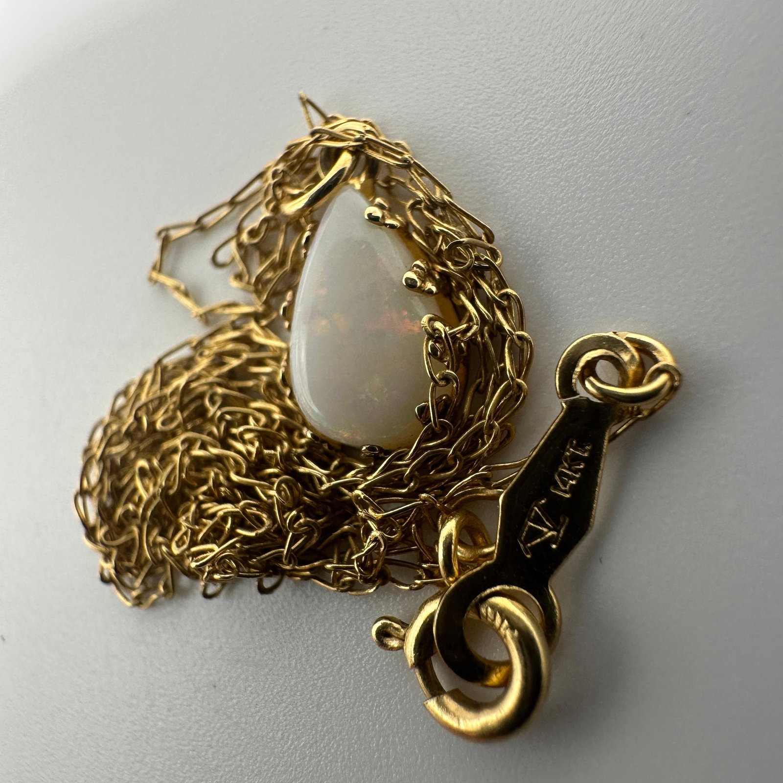 Teardrop White Opal Pendant Necklace 14K Yellow Gold: This item is in good pre-owned, previously used/displayed condition with noticeable light wear and surface scratches. Please reference all photos for full details. This piece of jewelry has been teste