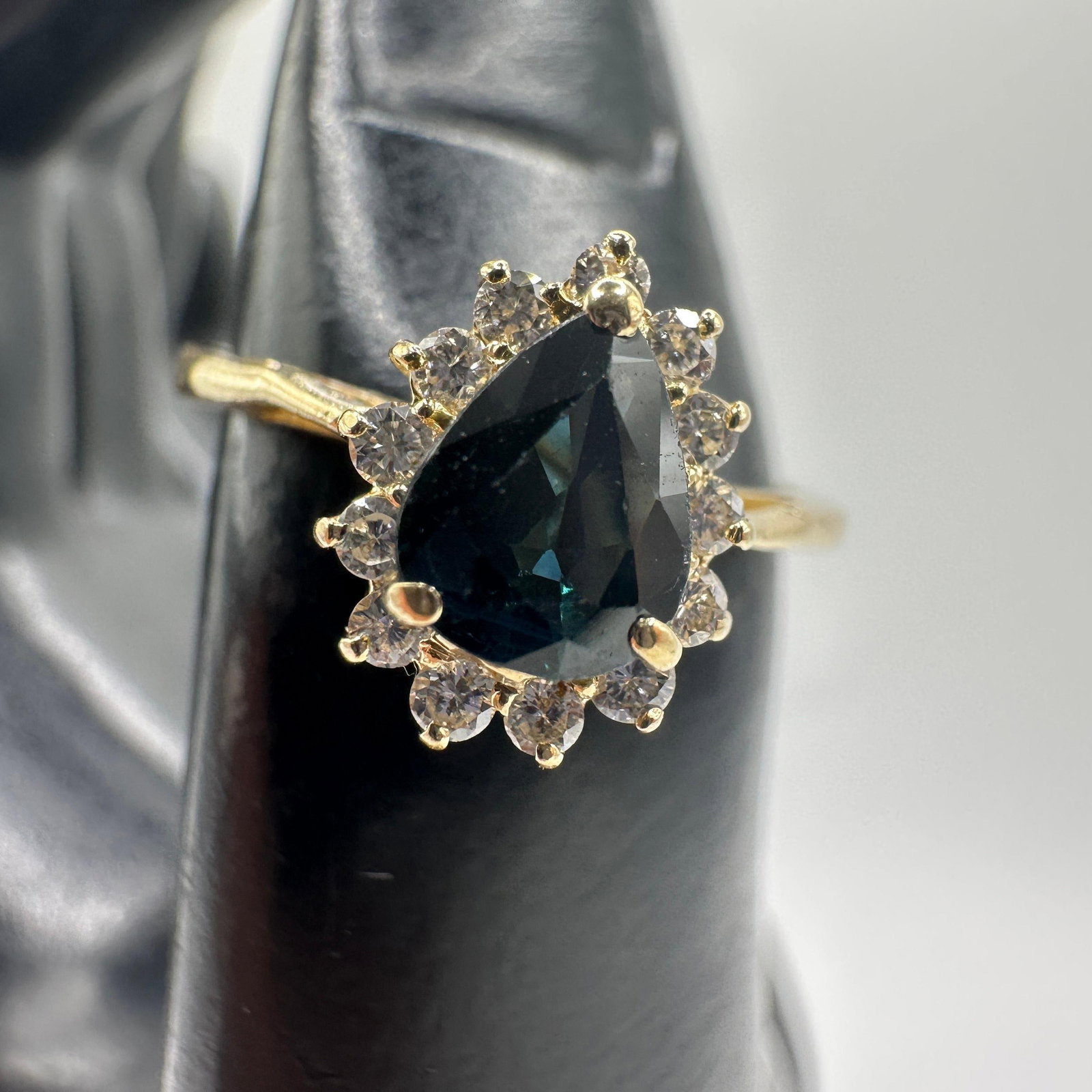 Pear Blue Sapphire Diamond Encrusted 14K Yellow Gold Ring: This item is in good pre-owned, previously used/displayed condition with noticeable light wear and surface scratches. Please reference all photos for full details. This piece of jewelry has been teste