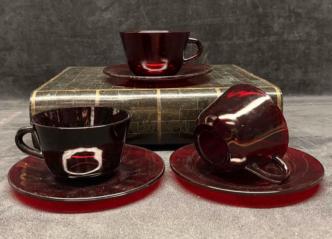 Set of 3 Vintage Anchor Hocking Red Ruby Glass Teacup and Saucer Set: Produced by Anchor Hocking Glass Corporation, these mid-century pieces were manufactured starting in 1938 and remained popular through the 1960s-1970s. The set features a smooth, solid deep-red color 