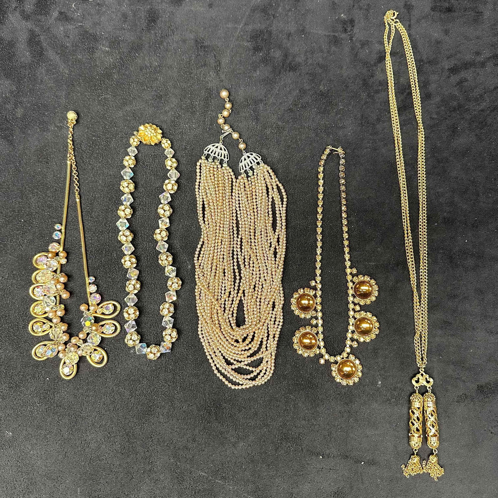 Assorted Costume Jewelry Necklace Set Lot of Five Necklaces K54: Costume Jewelry Necklace Set Lot of Five Necklaces. Various costume jewelry necklaces, five pieces included with some faux pearl, gold tone, floral clasp, multi strand, plastic and glass beads, and ot
