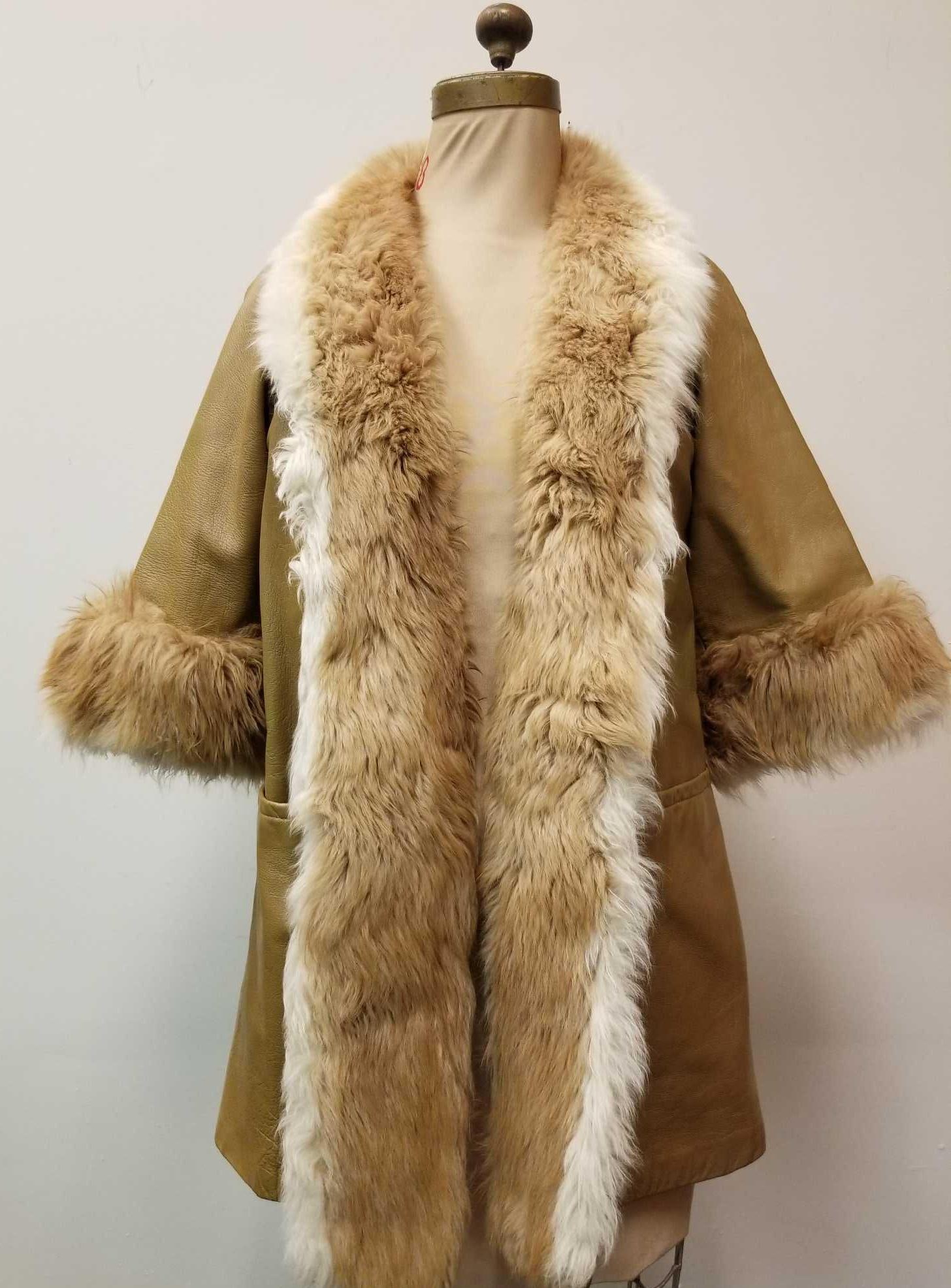 Leather with Shearling Trim Coat by Dan Di Modes: This leather with shearling trim coat by Dan Di Modes is in good used condition with some light fading on the exterior underneath the arms from storage keeping (see image) and some separatio