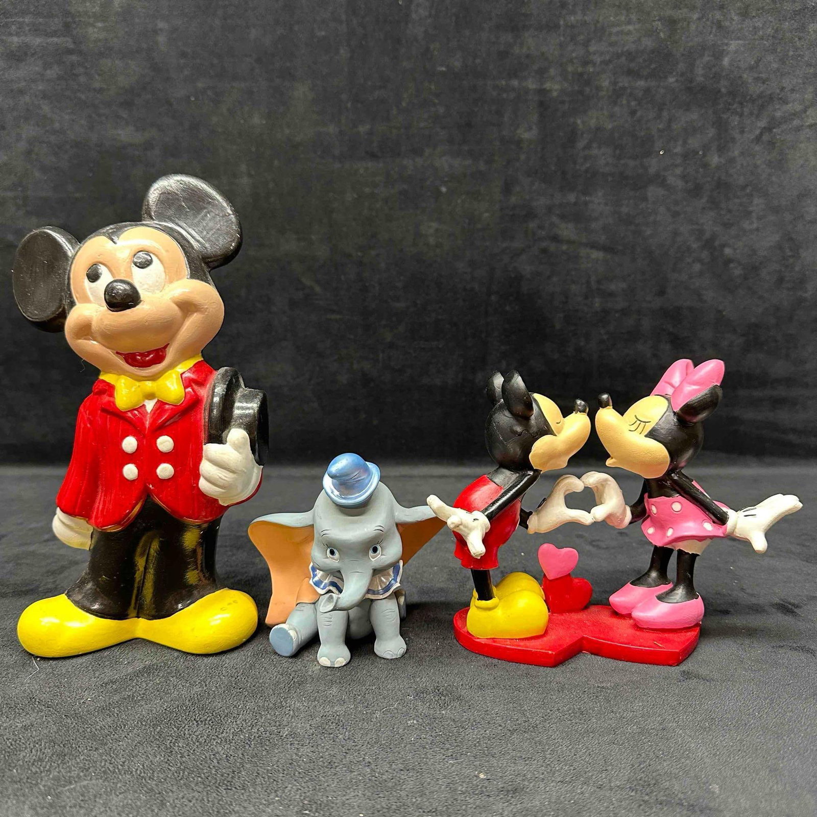 Disney Figurine Set Minnie and Mickey Mouse Dumbo Figures: Each figure shows minor markings and staining. The Minnie and Mickey Mouse kissing and Dumbo figure are made of resin while the older in age Mickey Mouse Walt Disney Productions figure is made of cera